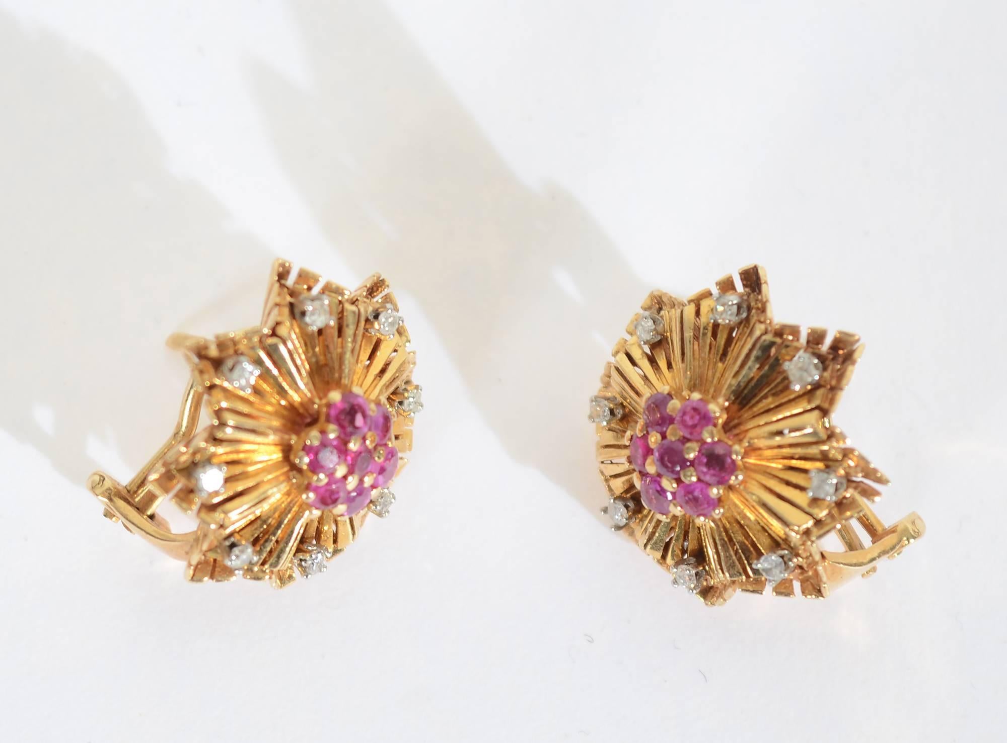 These Retro earrings were made in the 1940's but as stylish as if made today. 
A diamond is cradled within each three dimensional arm of the star. Seven rubies are clustered in the center.
The earrings are 13/16