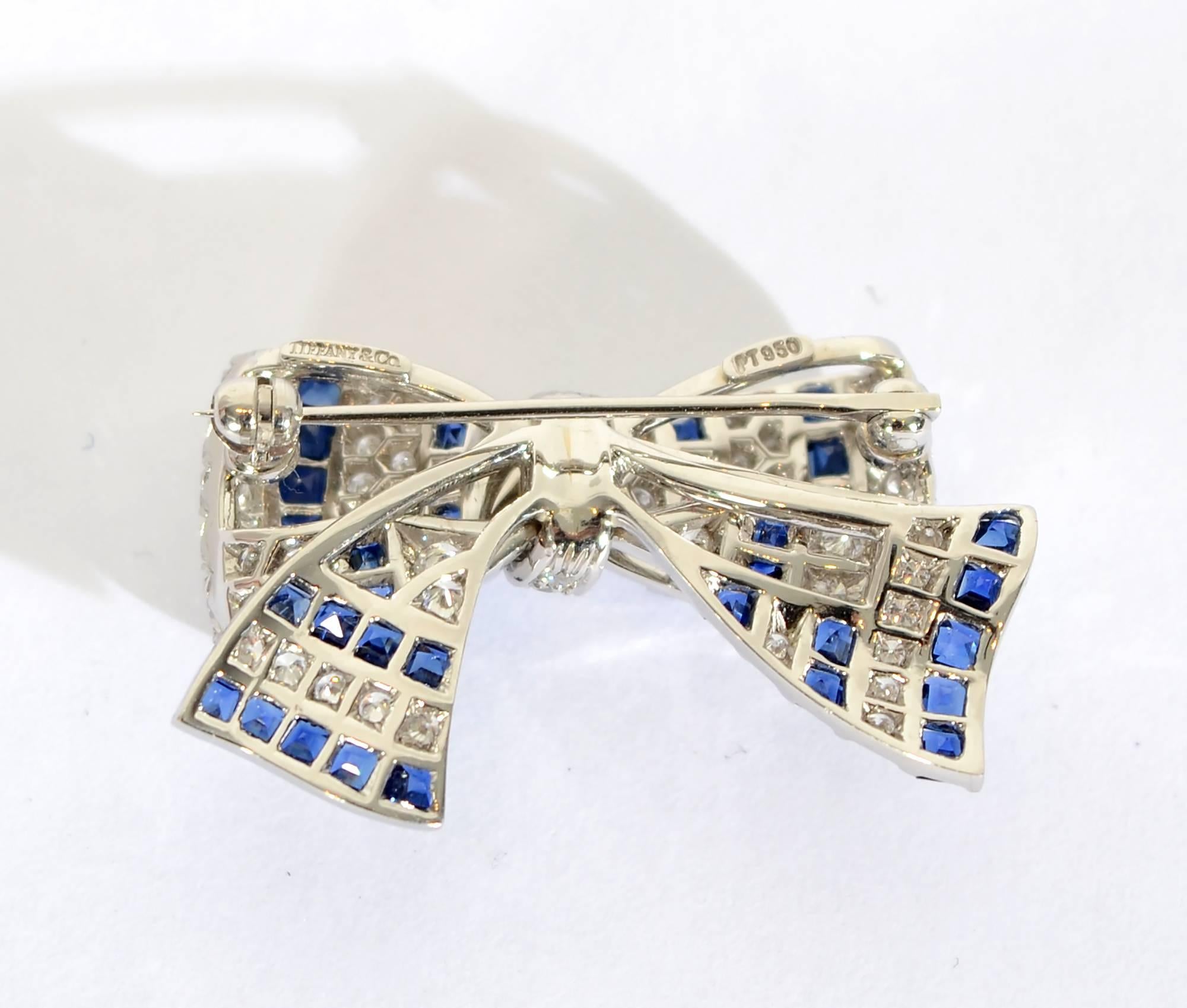 Graceful and elegant bow pin by Tiffany and Co. Natural Burmese sapphires and diamonds are set in platinum. The brooch is finely made to look as though it has the  delicate movement of ribbon. It measures 1 1/4" wide and 7/8" tall.