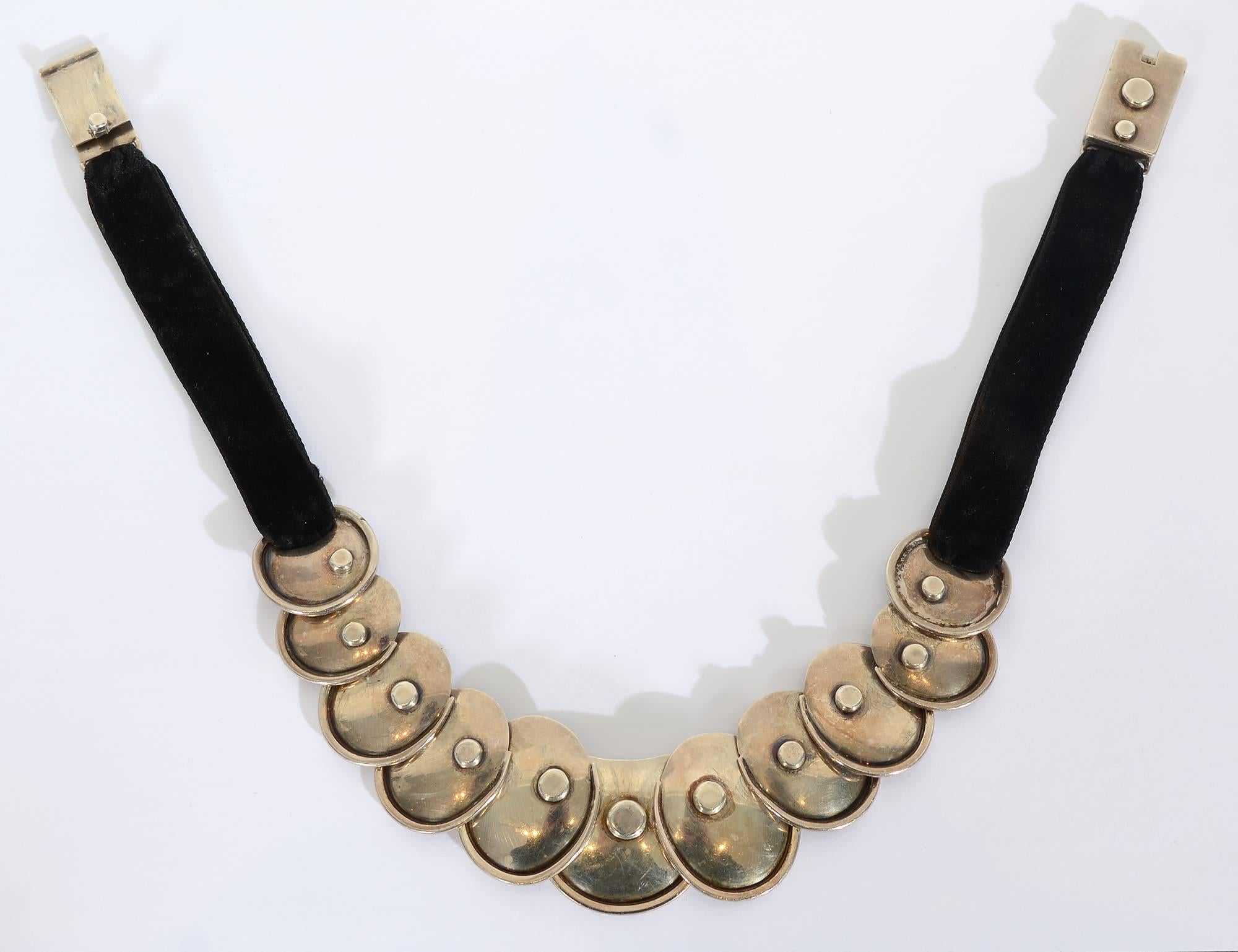 This Armadillo necklace by Hector Aguilar was one of his most popular, rarely seen designs. Eleven oval silver discs overlap and are connected with rivets that are both decorative and functional in that they allow the discs to move freely. The discs