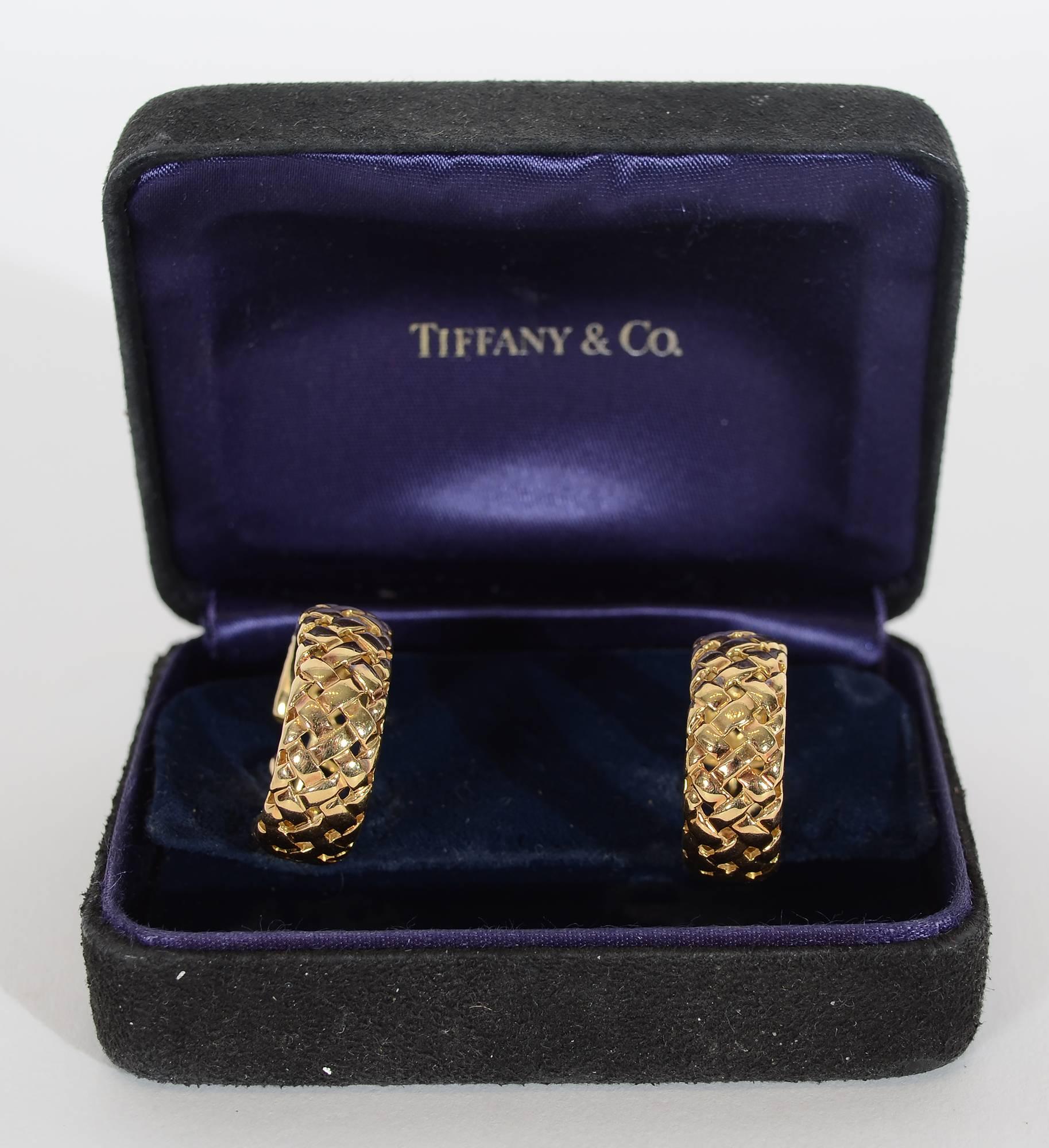 Basketweave hoop earrings made by Tiffany in 18 karat gold. Dated 1995. Post and clip backs. Measure 3/4