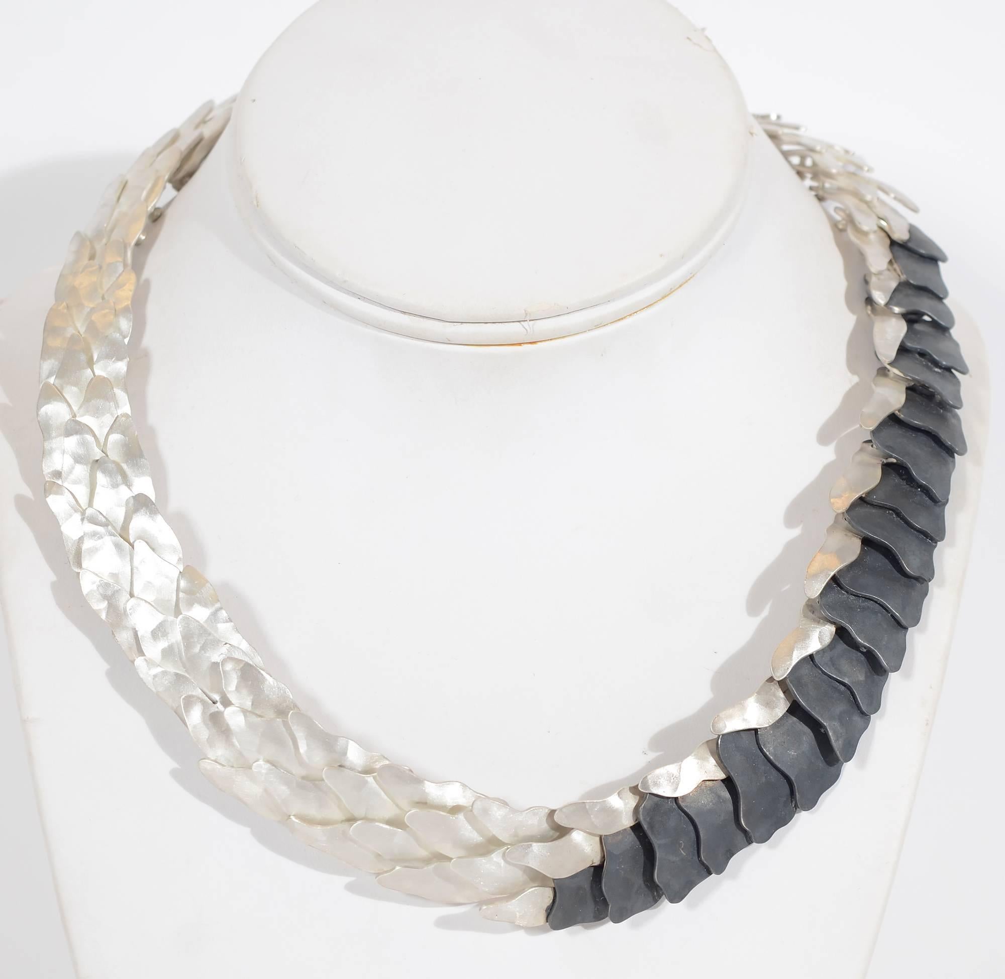 Striking necklace made of two tones of 950 silver, higher quality than sterling. The black has been oxidized to create the dark matte finish.
Overlapping links are assembled with rivets giving lots of movement to the necklace. The darkened part can