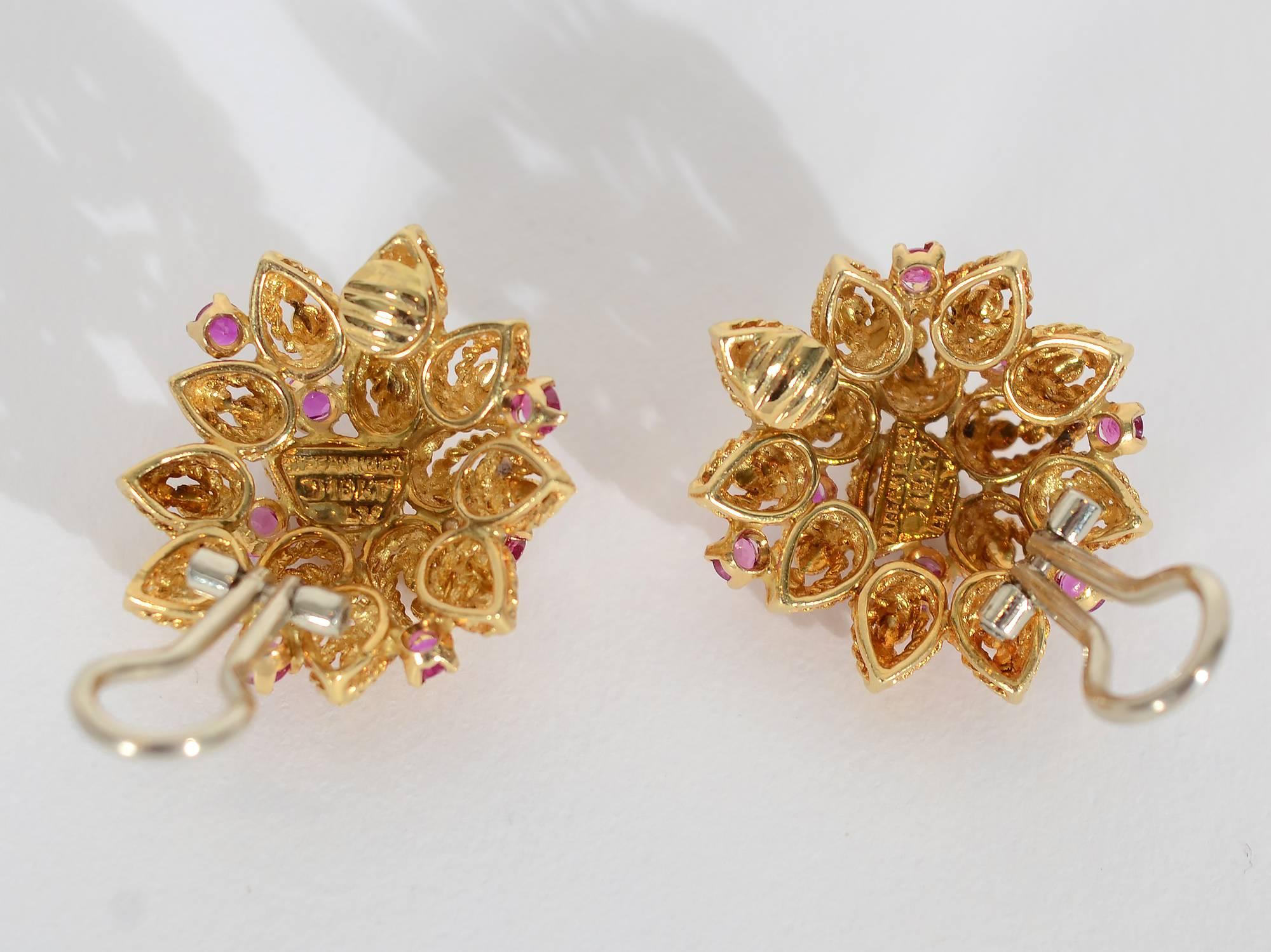 Overlapping pear shaped petals are highlighted with 7 rubies in each of these unusual Tiffany earrings. The petals are intricately made of two outlines of twisted gold centered with gold balls. Clip backs can be converted to posts. The earrings