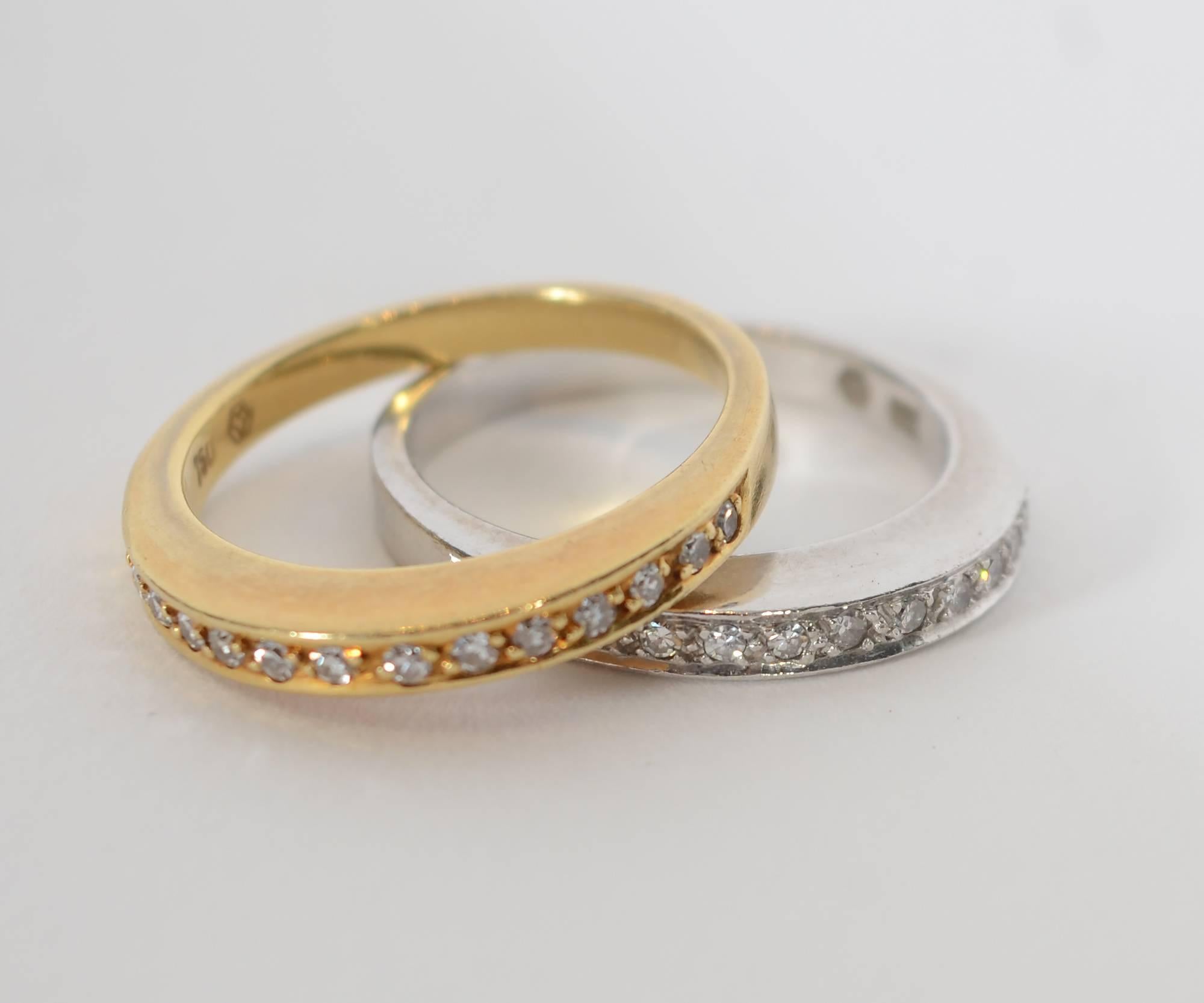 This pair of yellow and white gold diamond band rings was made by Victor M. Since 1989, Victor M has been the sole producer of jewelry for Faberge. The rings each have 15 diamonds with a total weight of about 1/2 carat. The rings are a hair larger