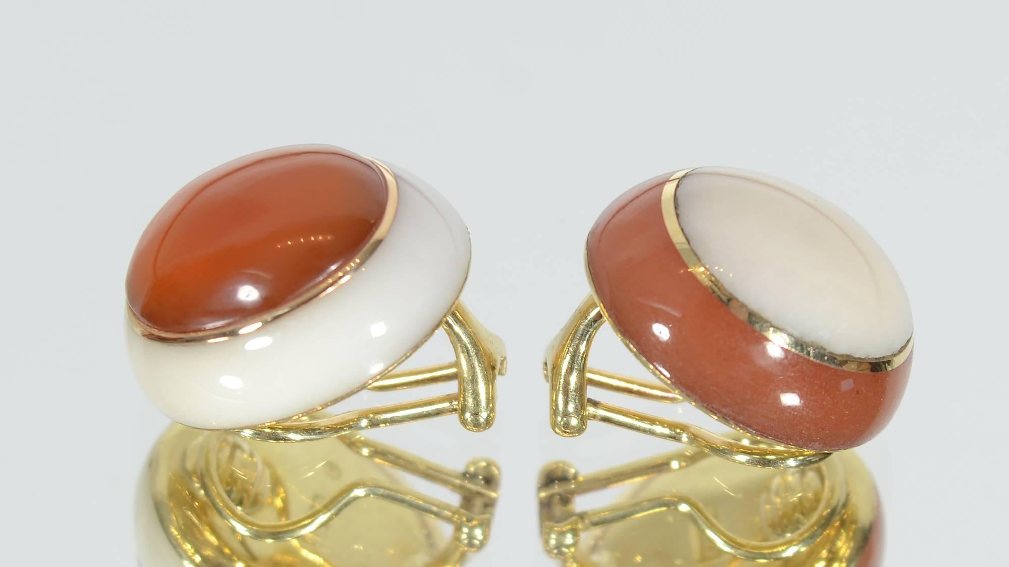 In this wonderful pair of Tiffany Yin Yang earrings, the center of one is carnelian with a white coral exterior and the reverse on the other. On both, the two different stones are separated by a gold band. Clip backs can be converted to posts.