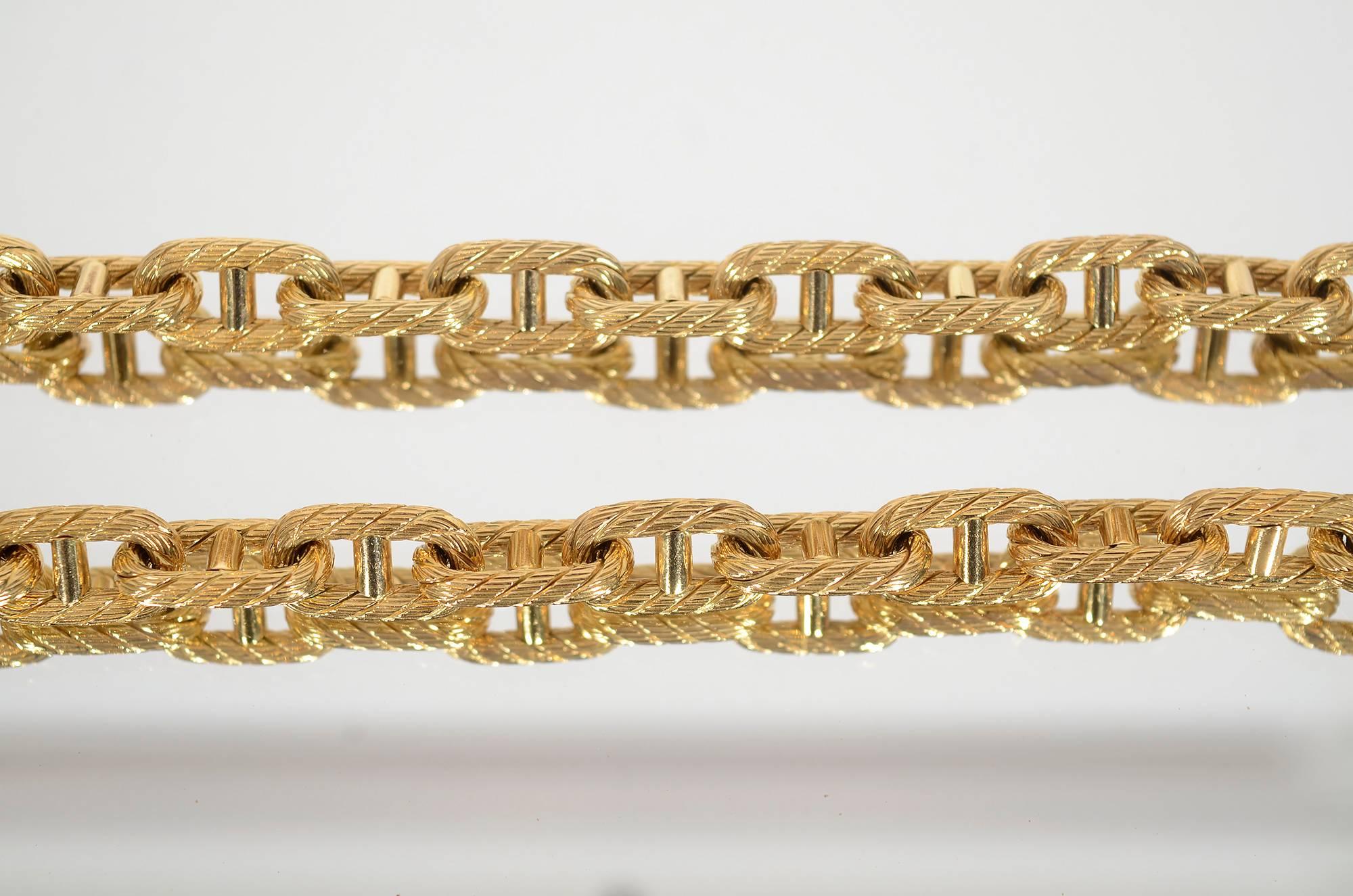 Pair of 18 karat gold bracelets with oval links in a textured rope design. The bracelets are 8 1/4 inches in length and the links are 7/16" wide. Both have safety clasps. Priced for the pair.