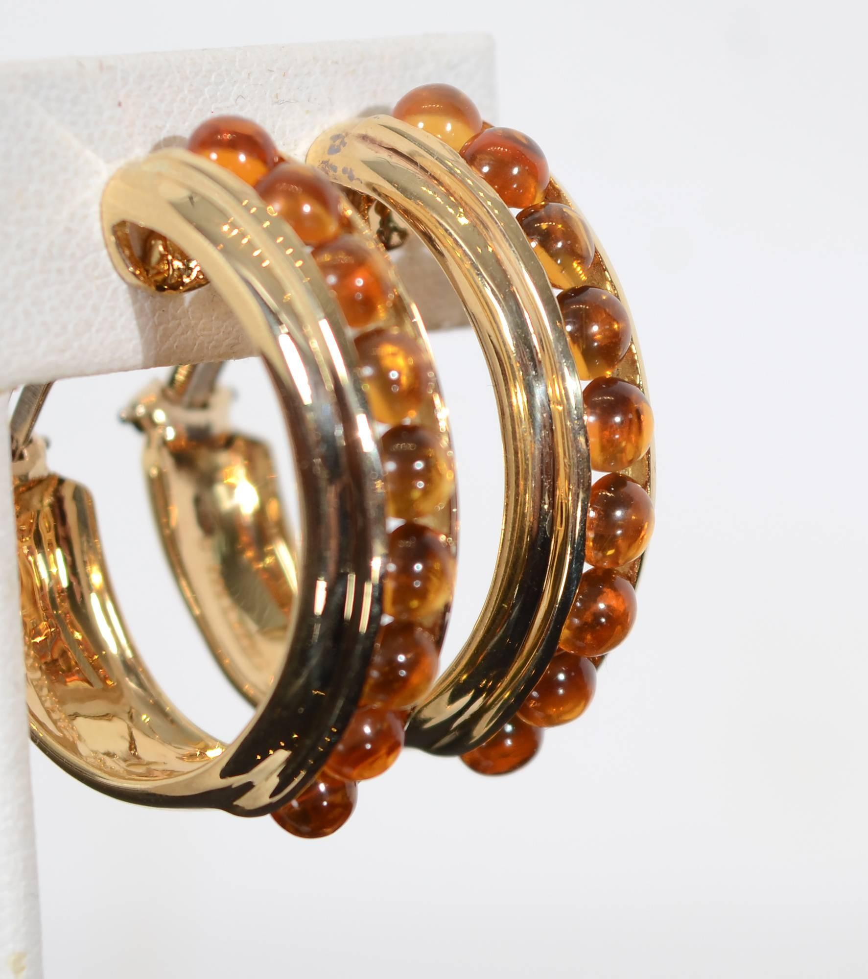These hoop earrings are slightly oval in shape with 9 cabochon citrines in each one. The sides are nicely banded. Clip backs can be converted to posts.