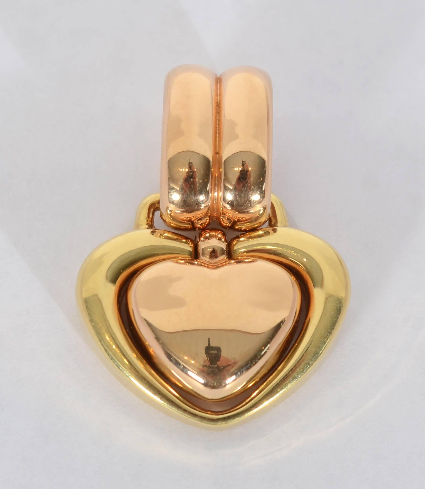 Three dimensional heart pendant by Chimento. The center heart and hanging loop are rose gold; the outer heart is yellow gold. The center heart swivels. The loop is large enough to easily fit virtually any chain or velvet necklace.