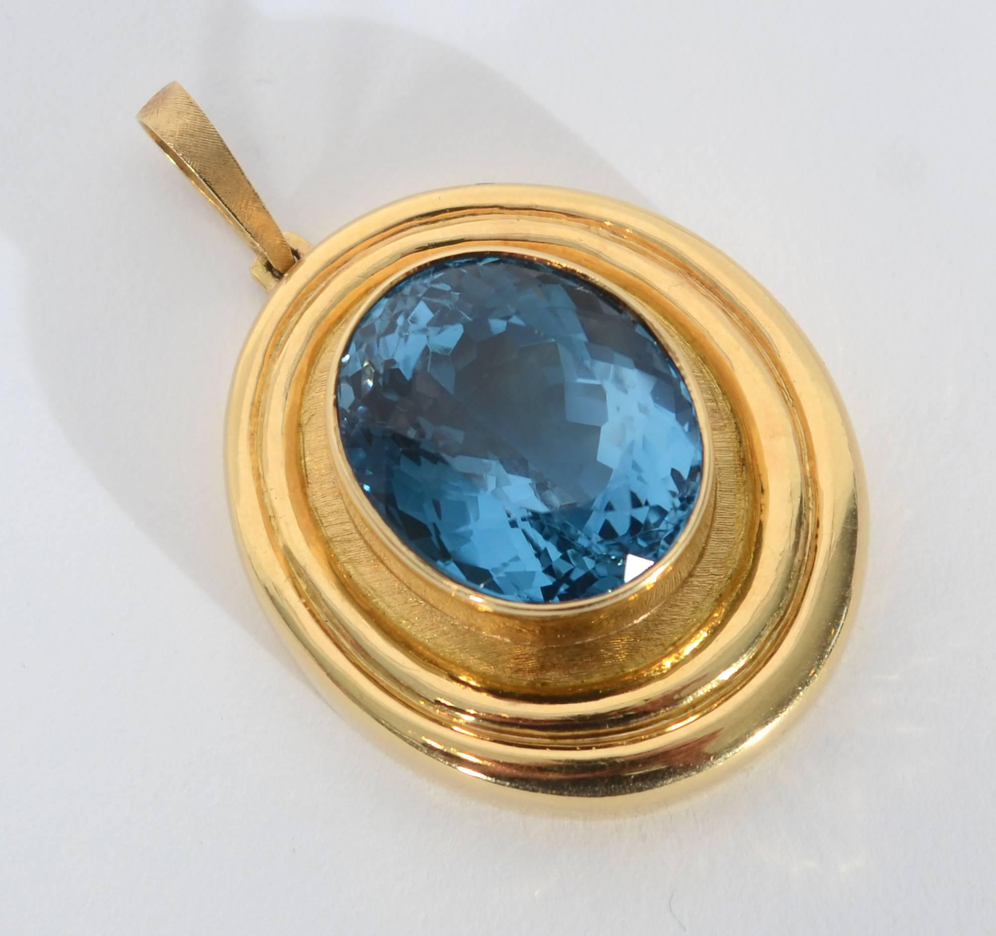 Stunning oval pendant by famed Brazilian brothers, Roberto and Haroldo Burl Marx. The central blue topaz weighs 37 karats.It is set in a glossy bezel surrounded by a slightly burnished oval. Outside that are two glossy ribbed frames. The variation