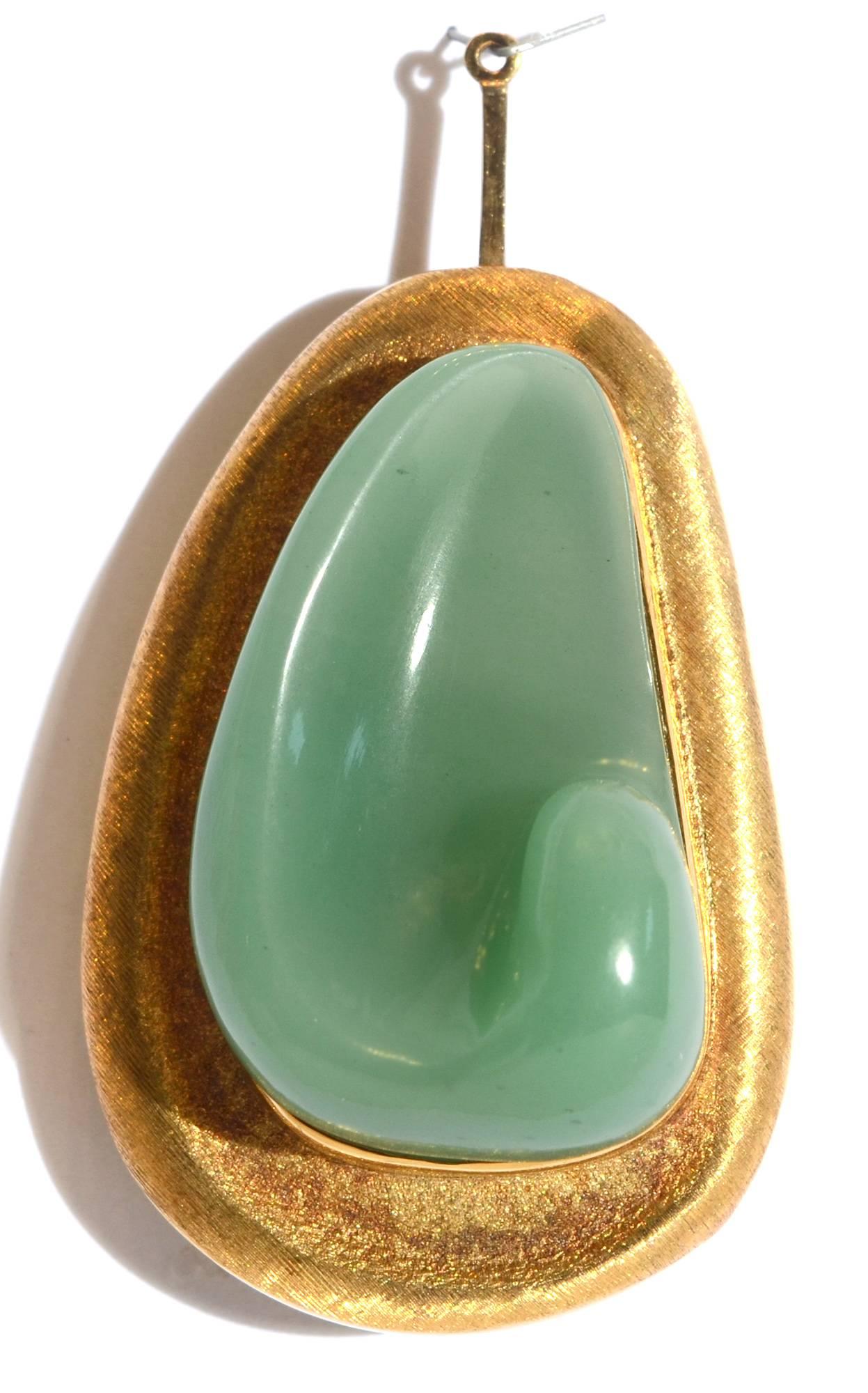 This chrysoprase forma livre piece by Burle Marx is both a brooch and a pendant. It has a cleverly designed retractable stem to allow it to be worn on a chain. The 18 karat gold frame around the carved stone has the lightly brushed finish often used