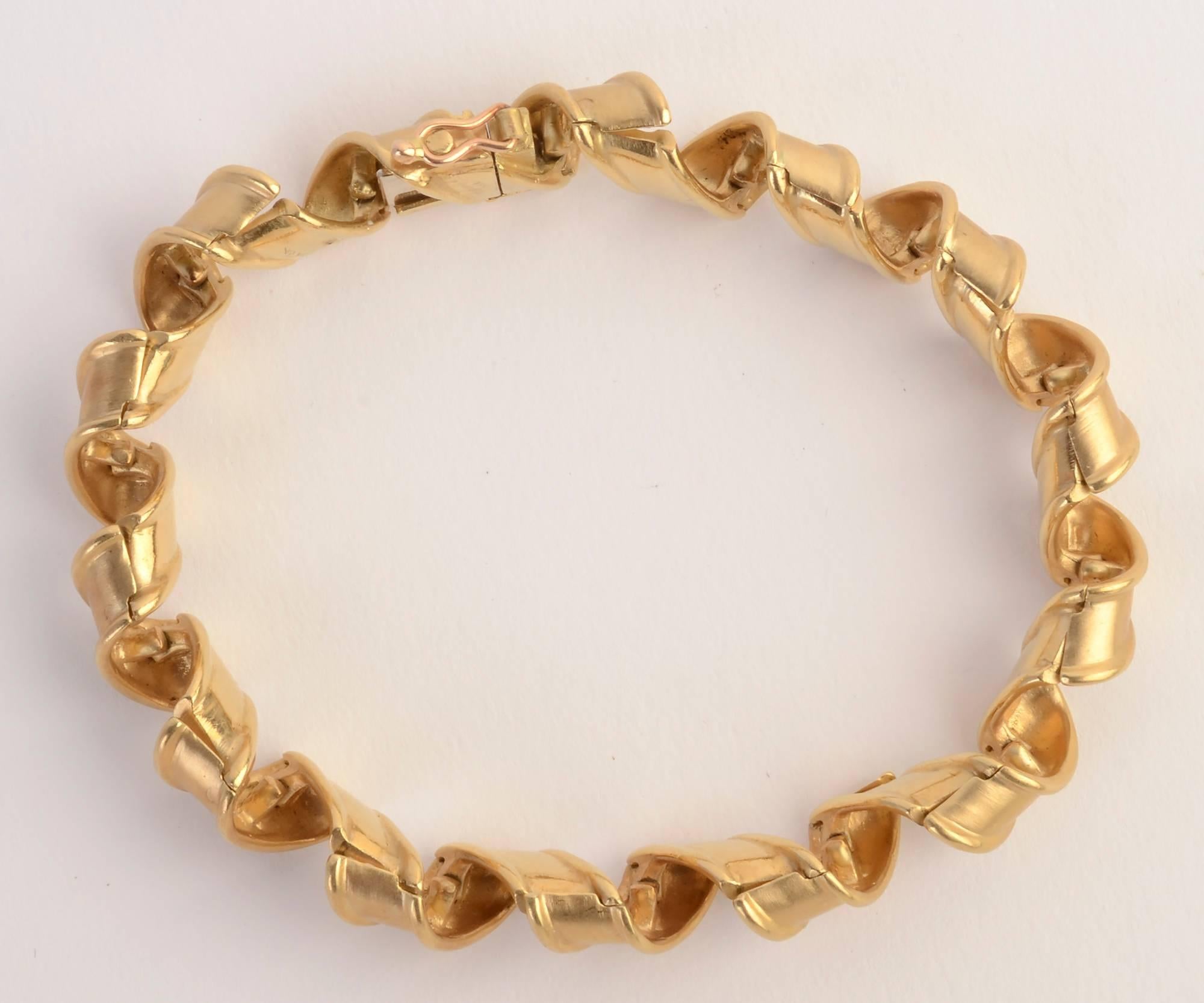 Graceful Tiffany bracelet in which the gold links effectively look like curled ribbon. Each link has two hinges to allow this to occur. The bracelet is 7 1/2 inches in length and half an inch in width. Made in France; circa 1960's.