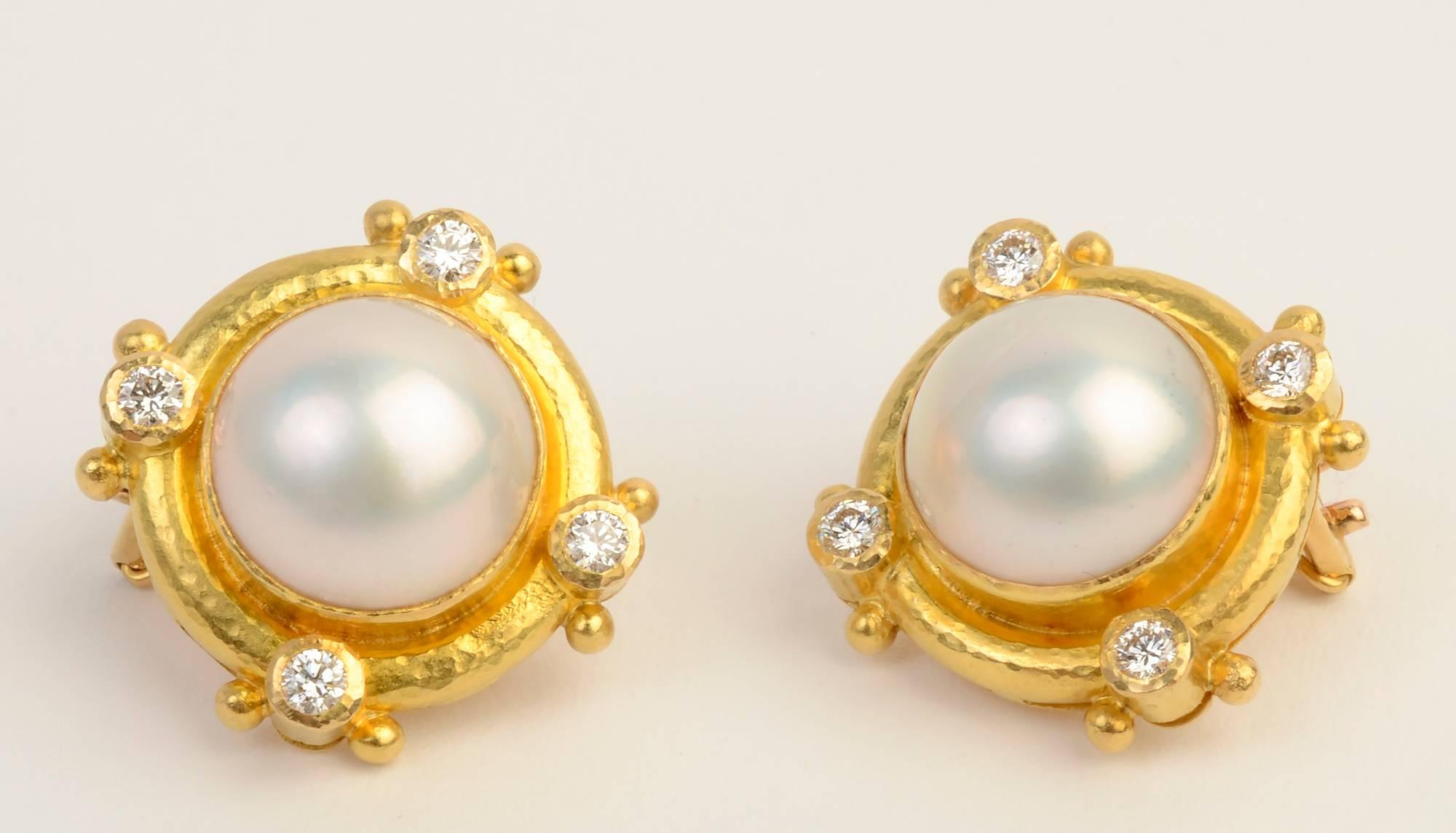 Elegant earrings by Elizabeth Locke with mabe pearls measuring 12.6 mm. Each is surrounded by four diamonds. They are set in the hammered gold finish for which Locke is known. Backs are posts and clips. Made of 19 karat gold. Accompanied by original