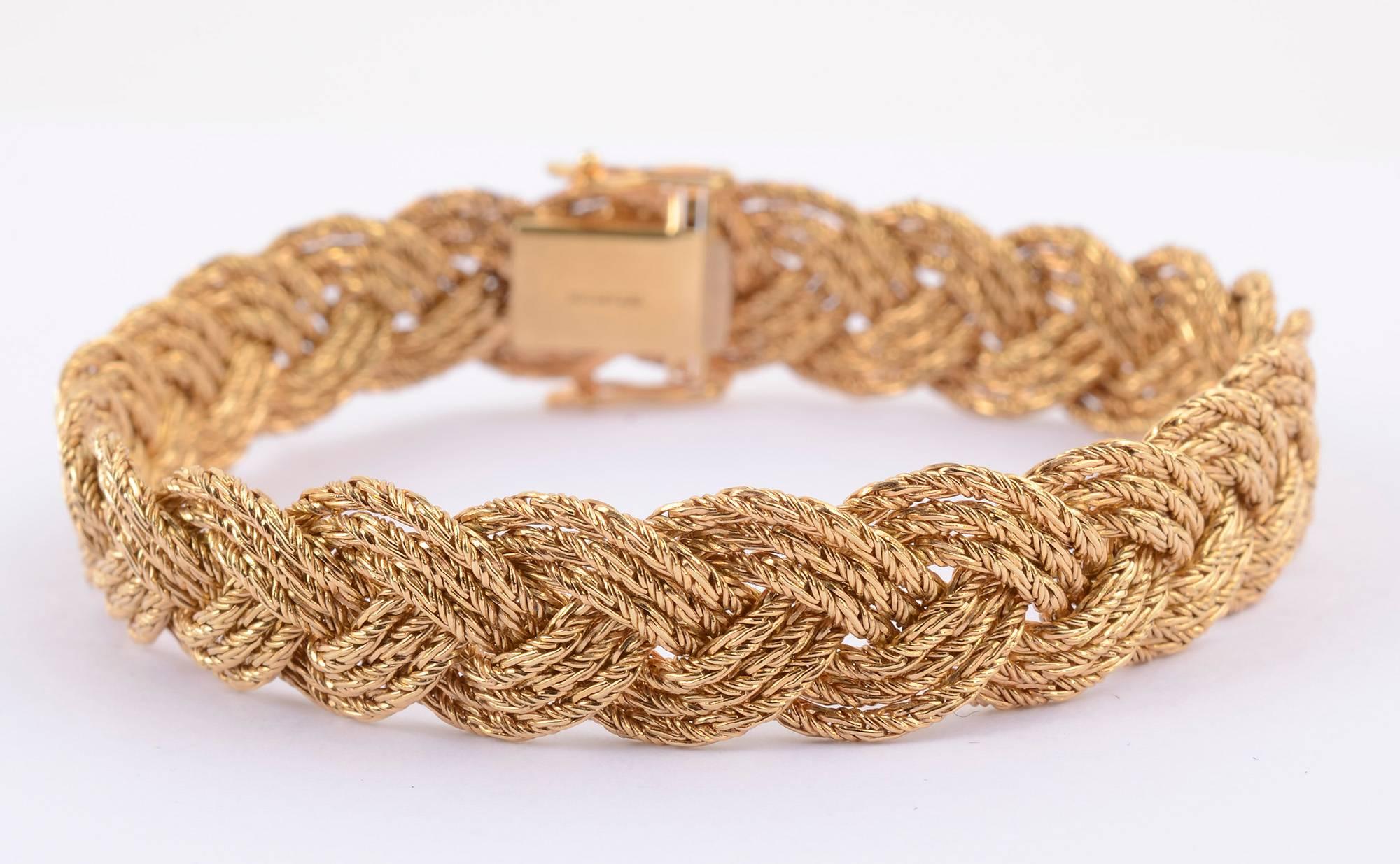 Beautiful eighteen karat gold bracelet  by Tiffany and Co. It is made of three braided strands of gold. Each individual strand is made with a herringbone weave. The complexity of the braiding with the herringbone gives a wonderful glimmer to the