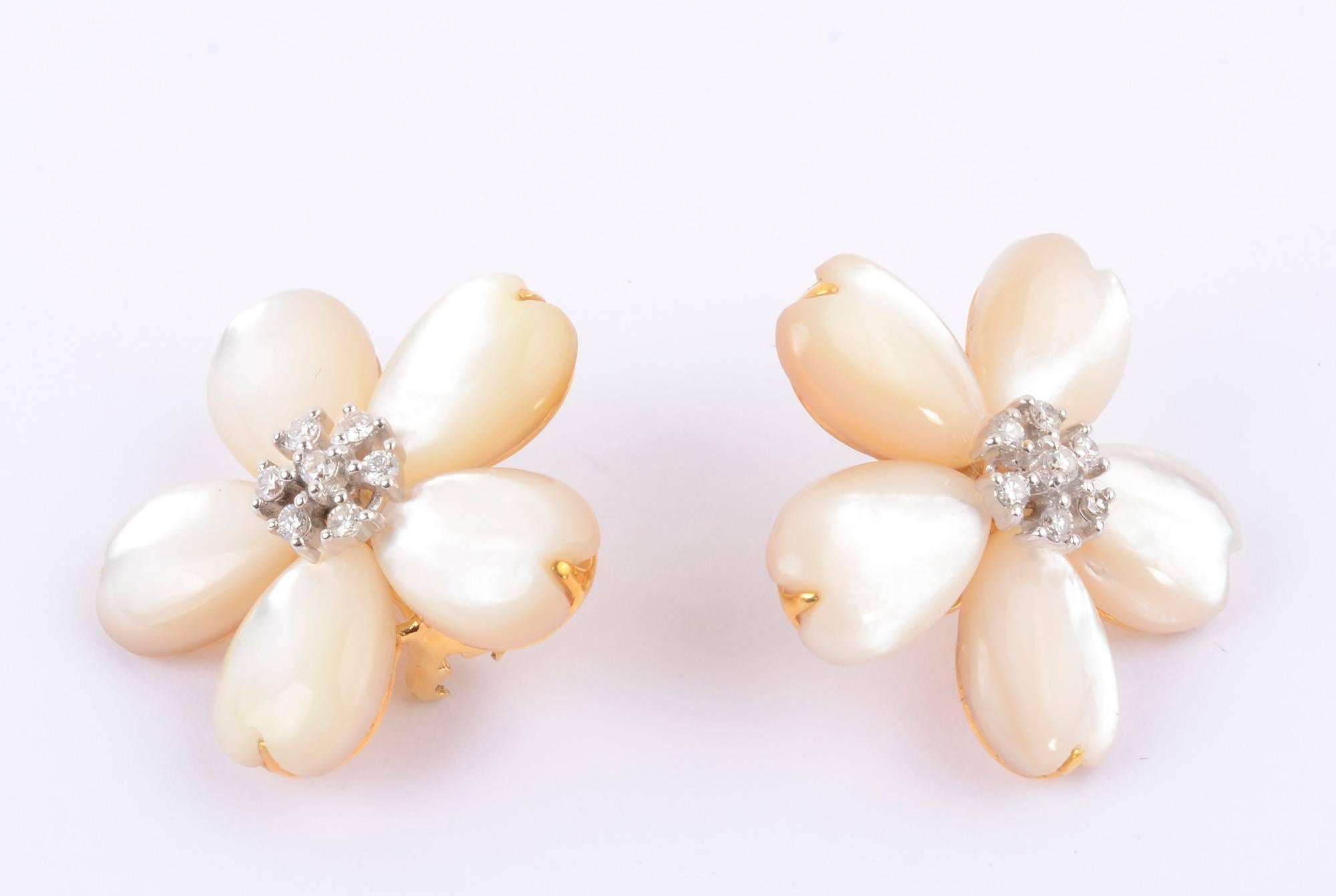 Light and graceful five petal flower earrings with the wonderful iridescence of mother of pearl. The centers are clusters of round brilliant cut diamonds weighing a total of .42 carats. The gold backings are brought around to the front of each