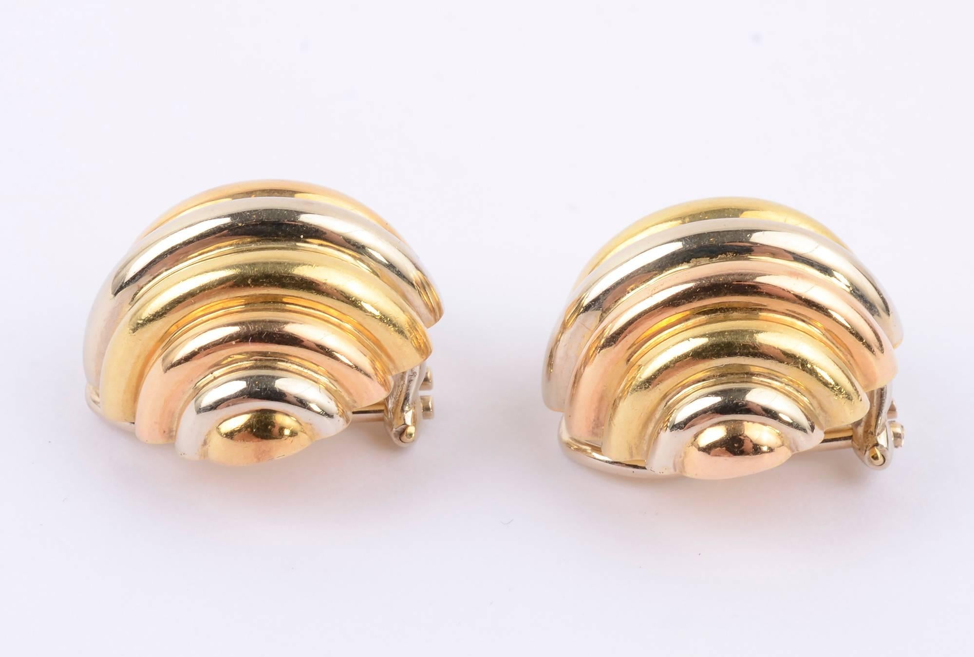 Cartier ear clips with the tricolor yellow, pink and white gold for which they are well known.  The  oval, ribbed design is an unusual one. Measurements are 1 inch wide and 7/8 inch tall. Clip backs can be converted to posts.