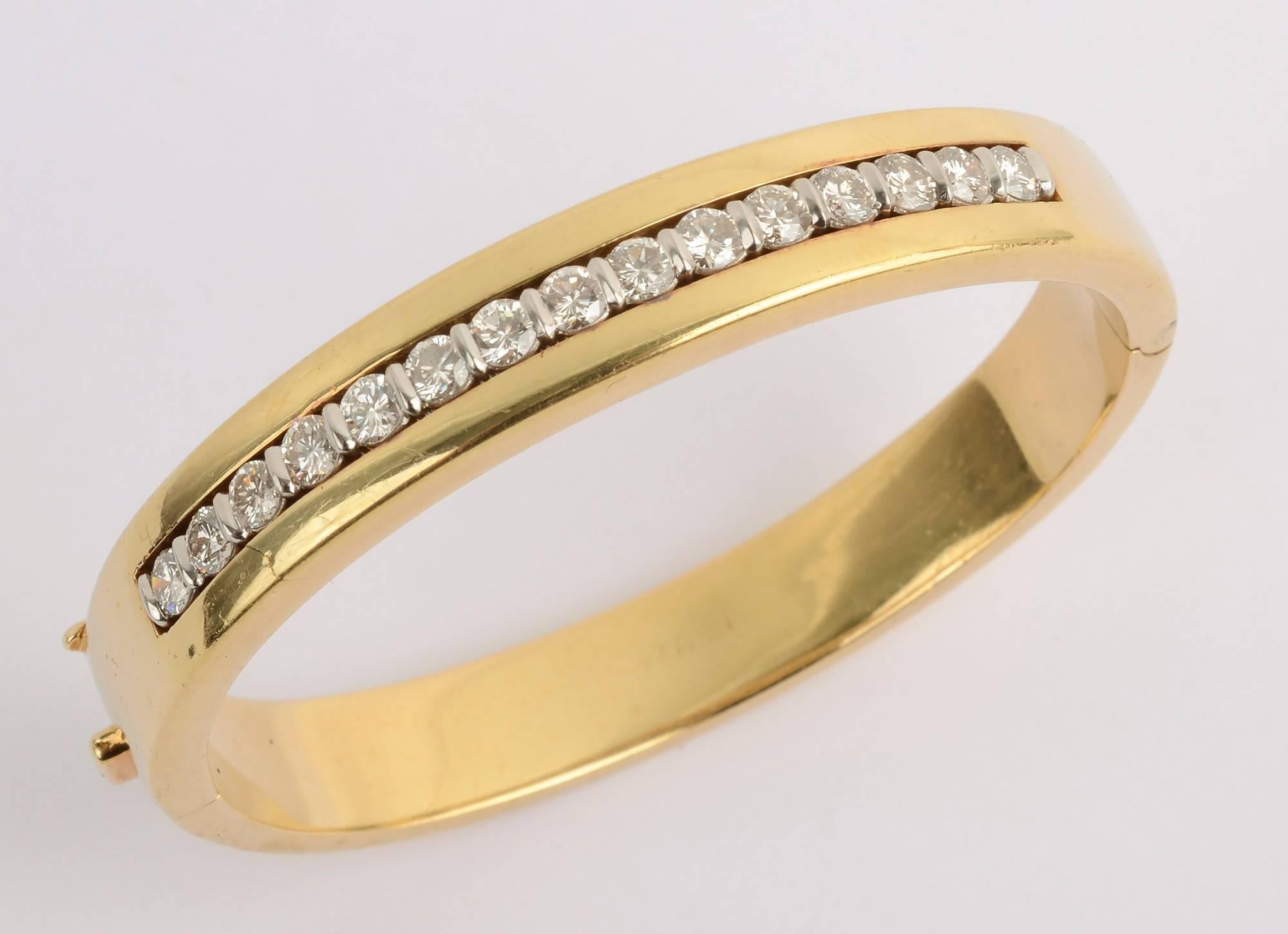 Eighteen karat gold hinged bangle bracelet by Tiffany with diamonds set in platinum. The bracelet has 15 diamonds that weigh a total of 2.25 carats. The bracelet is very secure with a good safety clasp. The interior measures 2 1/8 inches fitting a