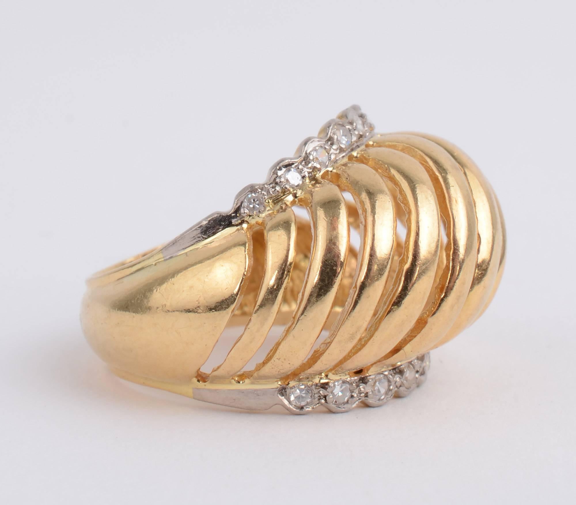 This domed gold ring with diamonds is an unusual one for the Greek designer, Ilias Lalaounis. The domed part is made of graduated width bands of gold alternating with open spaces. The dome is hugged by diamonds on top and bottom. The dome is 1/4
