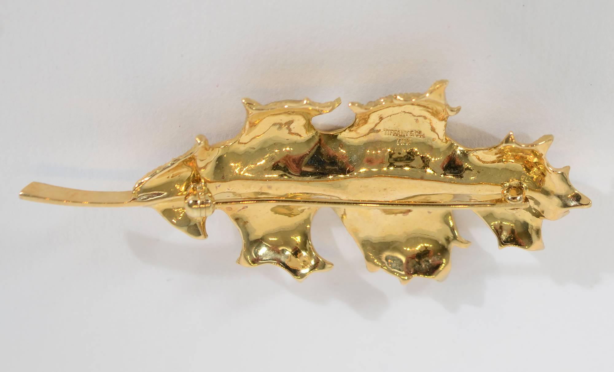 This 18 karat gold Oakleaf brooch by Tiffany conveys all the fine points of nature. The piece is beautifully detailed with veins throughout and a subtle texture. It is slightly convex with curled ends. Measurements are 2 7/16