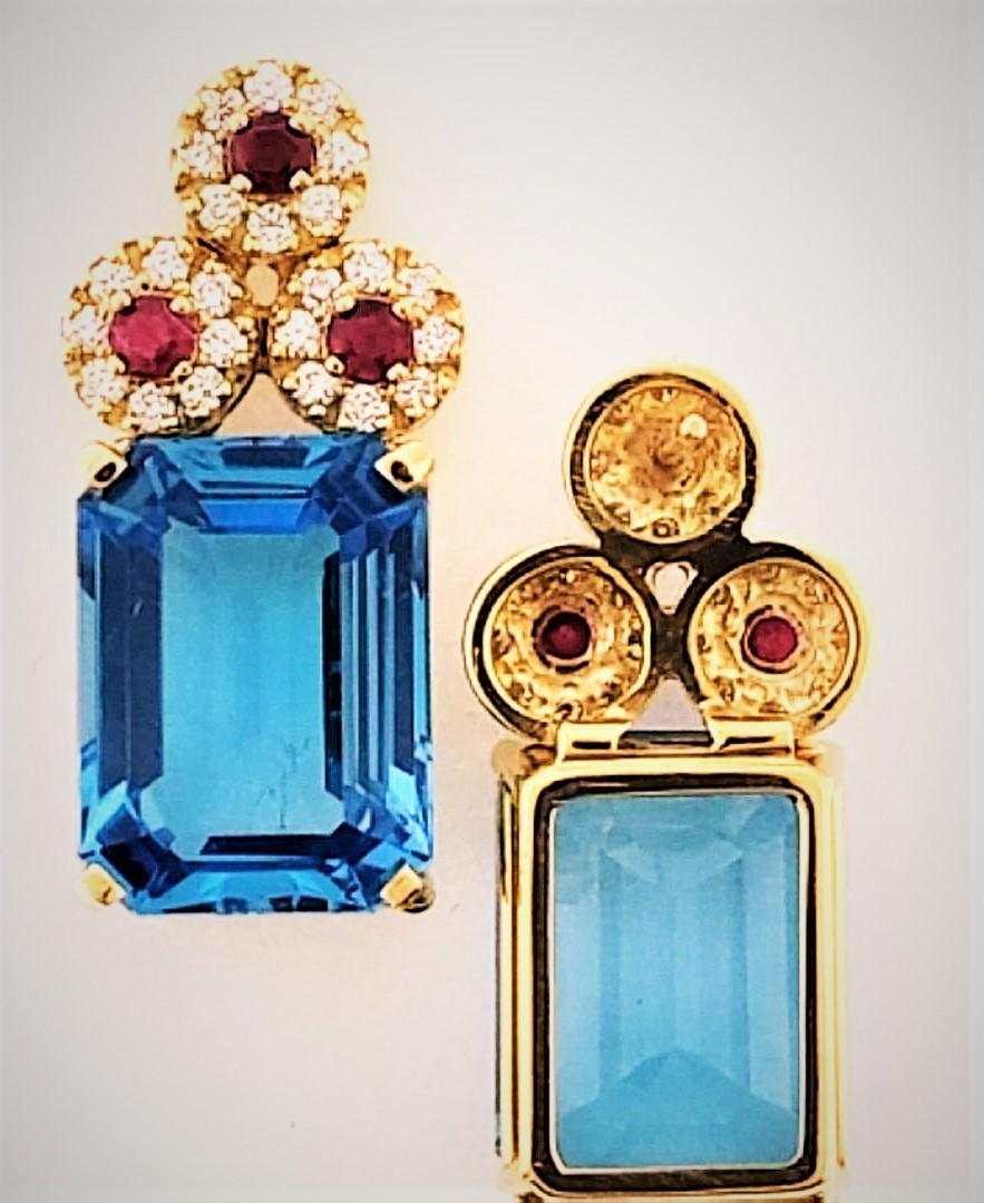 With color blending being a major factor in his creations, Michael Engelhardt has put together Blue Topaz (28.51 carats) Rubies (0.83 carats) and Diamonds (0.82 carats) in this beautiful pair of earrings.  The color blending brings out the color of