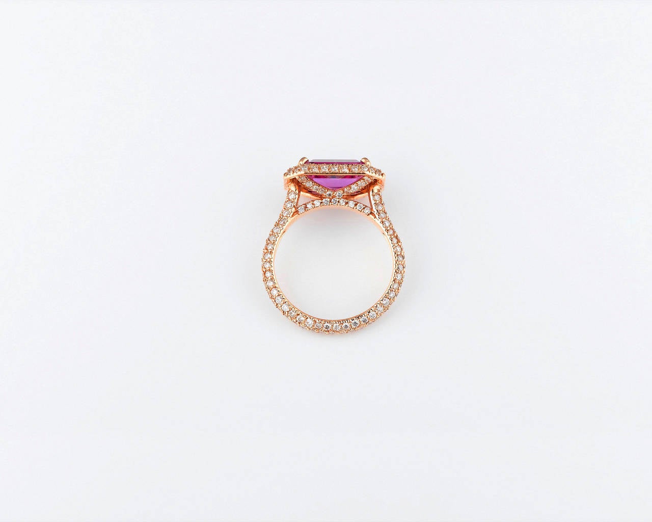 The 2.95-carat, natural pink sapphire in this elegant ring exhibits a distinctive violetish-pink hue, the rarest and most valuable color in which to find one of these legendary stones. This step-cut gem is certified by C. Dunaigre Consulting as a