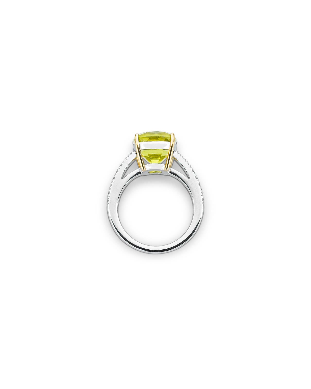 A stunning canary yellow tourmaline evokes all of the freshness of spring in this classic ring. Weighing 5.25 carats, this rare cushion-cut gemstone shimmers in its platinum and 18k yellow gold setting. 0.60 total carats of glistening white diamonds