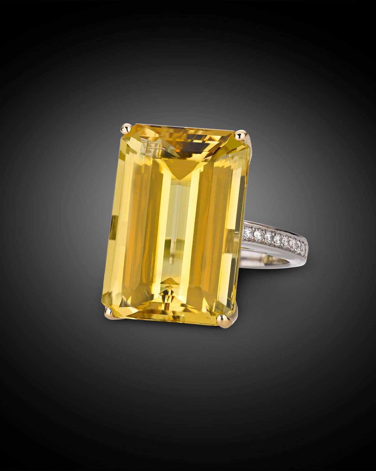 A brilliant octagon-cut golden beryl radiates at the center of this stunning ring. Totaling 28.15 carats, this beryl displays a rich golden hue that rivals the warmth of the afternoon sun. Colorless diamonds totaling approximately 0.34 carats
