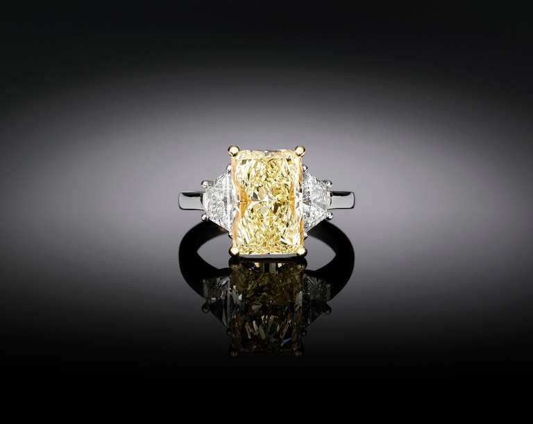 This magnificent, 4.75-carat Natural Fancy Yellow diamond displays the color of sunshine in this fabulous ring. Set in platinum and 18K yellow gold, this astounding radiant-cut gem is certified by the Gemological Institute of America (GIA) as being