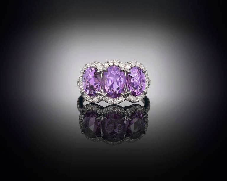 Three rare and stunning purple sapphires glimmer with distinctive color in this eye-catching ring. Weighing approximately 3.00 total carats, these enchanting rose-cut jewels exhibit a lovely, rich lilac hue, which is beautifully complemented by a