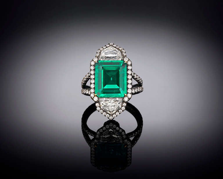 This opulent 4.69-carat Colombian emerald displays a richness and depth of color found only in the most prized gems. This step-cut gem's brilliant, verdant hue is perfectly complemented by approximately 3.11 carats of diamonds, including two