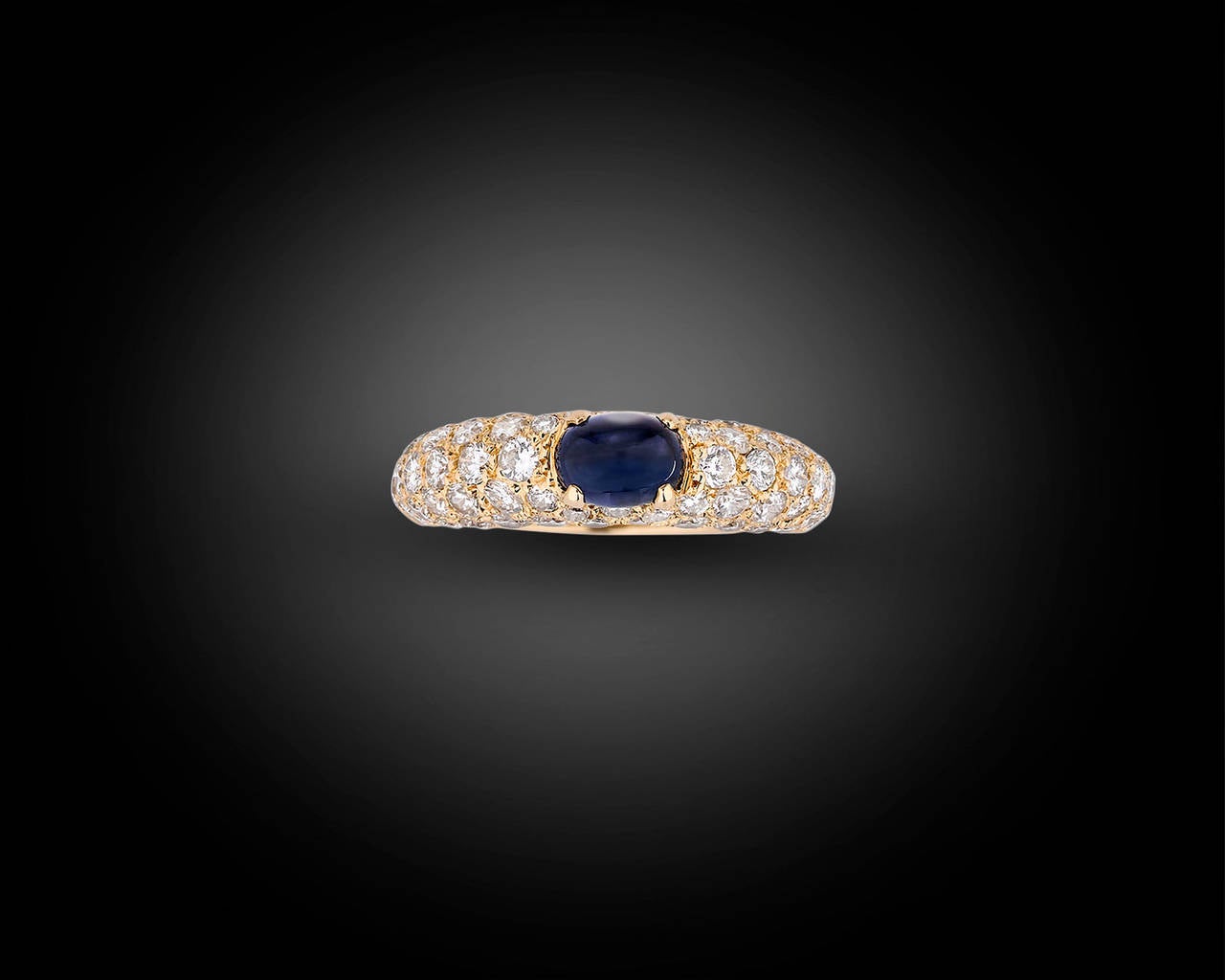 This classic and stylish ring from the celebrated house of Cartier boasts a modern elegance. Crafted of 18k yellow gold and set with 5 rows of shimmering diamonds, the elegant ring is further accented by a perfectly hued cabochon sapphire.

The