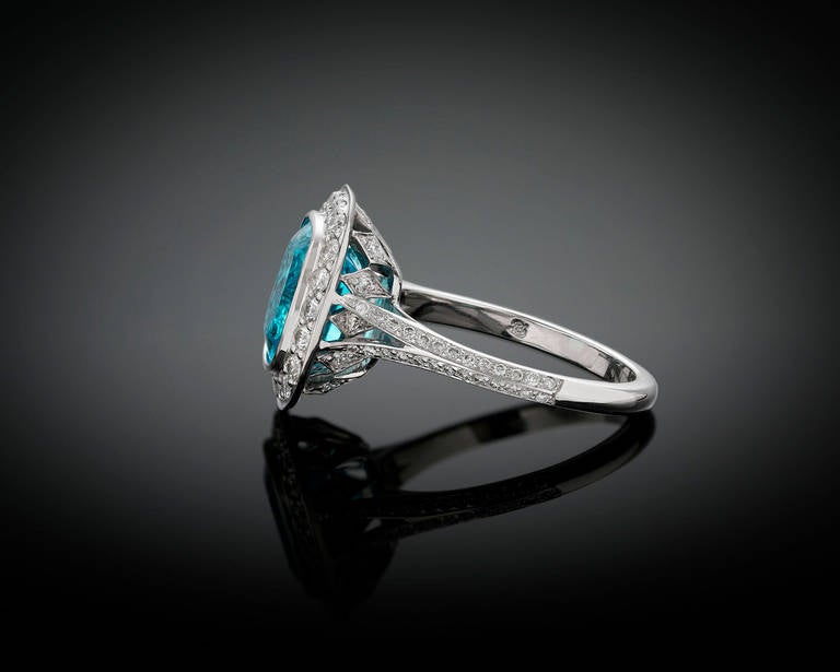 The sensational color of this 3.62-carat Brazilian Paraiba tourmaline hypnotizes in this platinum ring. This elegant, cushion-cut jewel is surrounded by 84 white diamonds totaling 0.64 carats. Paraiba tourmalines are among the most exciting