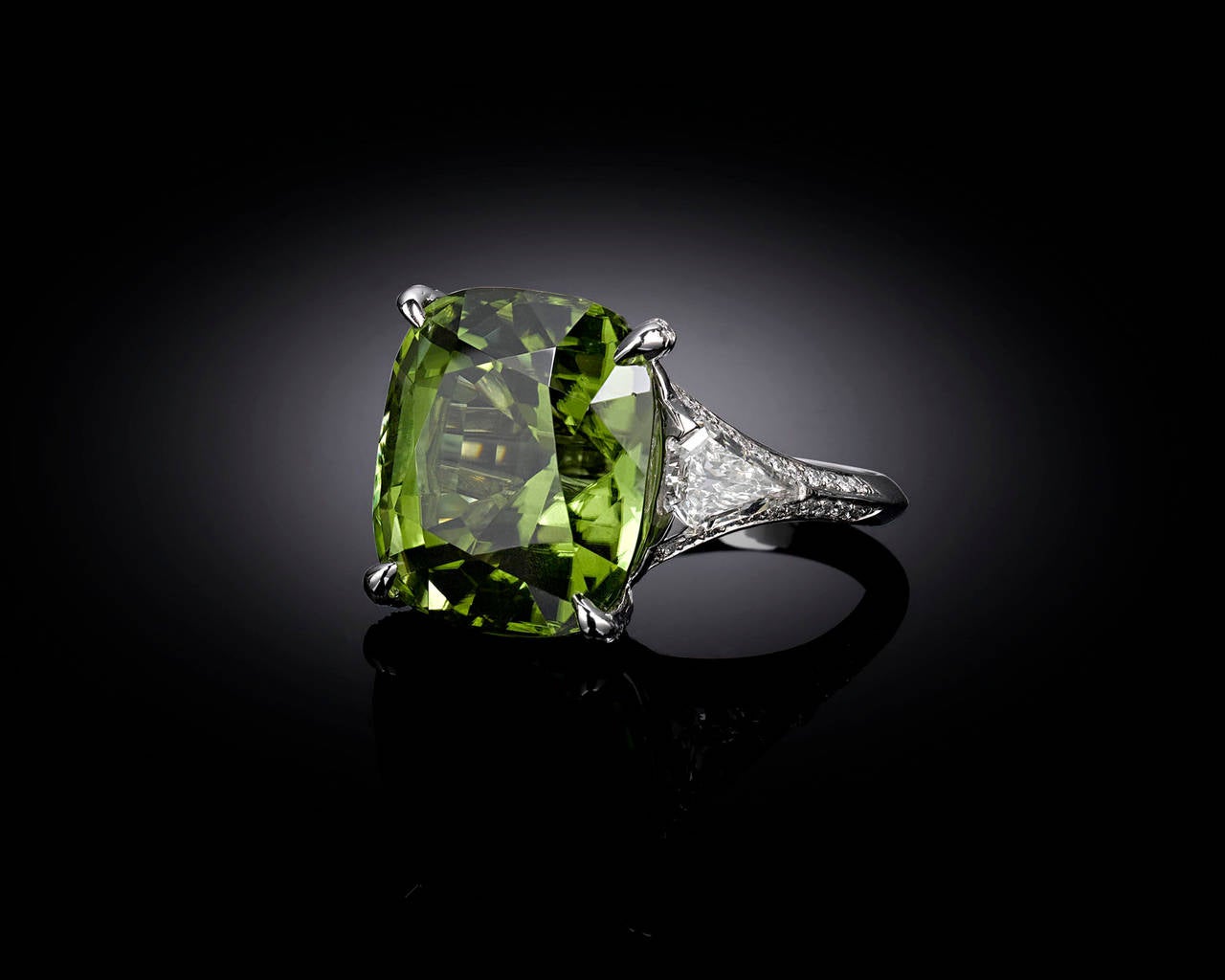 A mesmerizing 20.30-carat Burma peridot commands attention in this exquisite cocktail ring. Displaying the fresh, grass green hue for which peridots are so adored, this gem exhibits an uncanny clarity. Large peridots such as this tend to contain