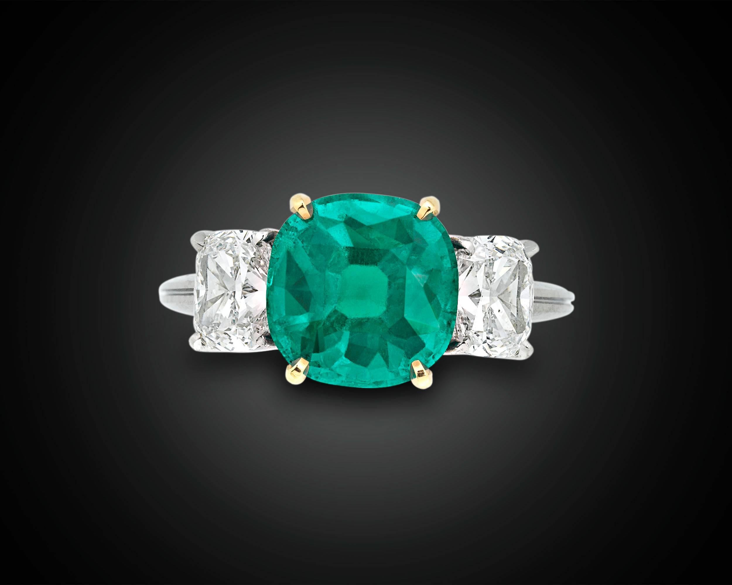 A stunning Colombian emerald exhibits an extraordinarily rare and coveted velvety hue in this captivating ring. Certified by the American Gemological Laboratories as being completely natural and untreated by oil, the 3.04-carat cushion modified