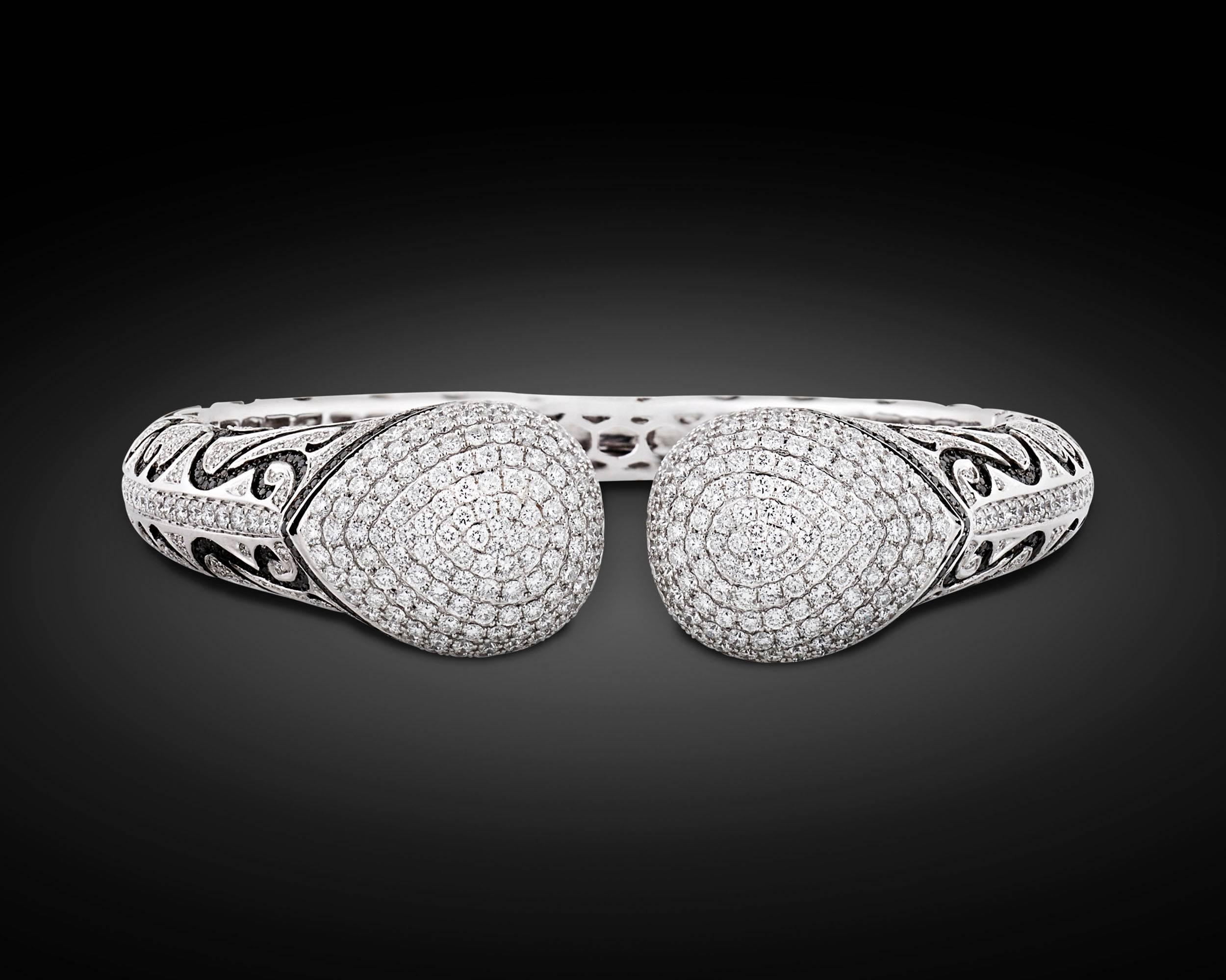 Black diamonds weighing 3.00 carats swirl in a sea of 6.59 carats of shimmering white diamonds in this outstanding cuff bracelet. The jewels, totaling 9.59 carats, are set within this brilliantly designed 18K white gold creation that is intended to