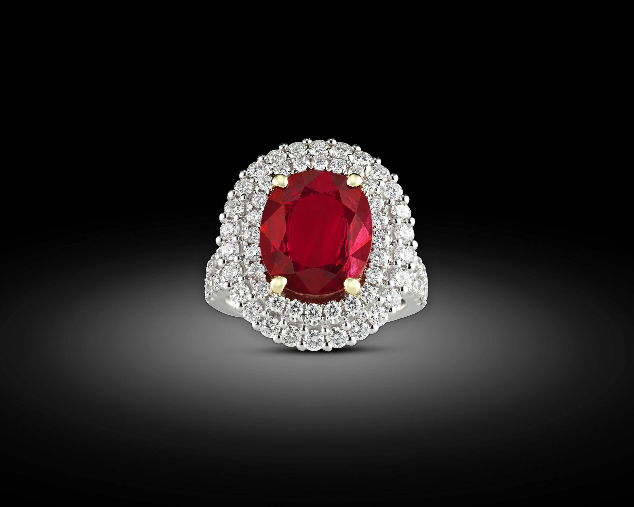A brilliant 3.95-carat oval Burma ruby radiates at the center of this elegant ring. The surrounding white diamonds, weighing 1.53 total carats, add to the dramatic glow of the striking gemstone. The diamonds form a bold double halo around the gem,