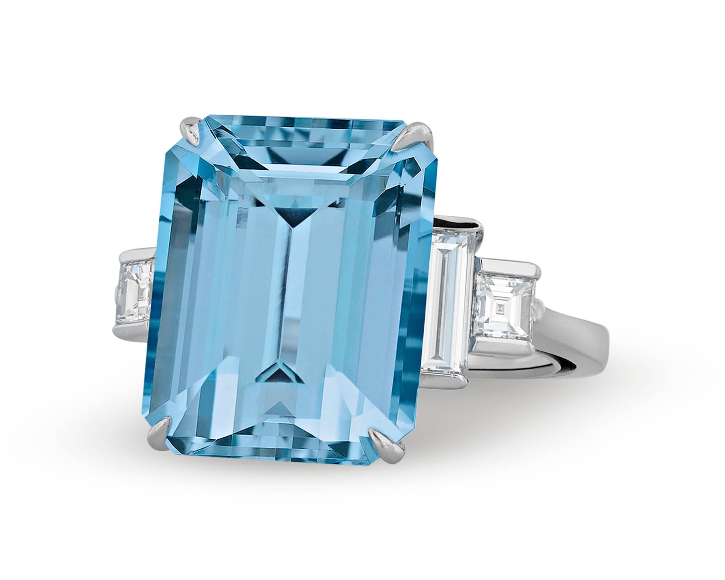 An exceptional emerald-cut aquamarine weighing approximately 15.00 carats is the star of this outstanding ring by Tiffany & Co. Sparkling with a pure ocean-blue hue, the gem is beautifully on display in a platinum setting studded with brilliant