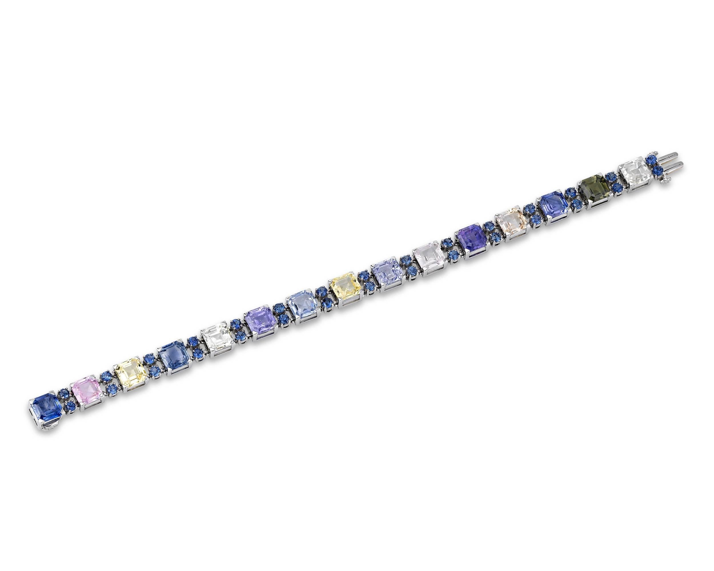 Fifteen stunning square sapphires, ranging in color from traditional blue to pink to green and all hues in between, present a sparkling rainbow of hues in this amazing bracelet by the celebrated Oscar Heyman. These magnificent gems are certified by
