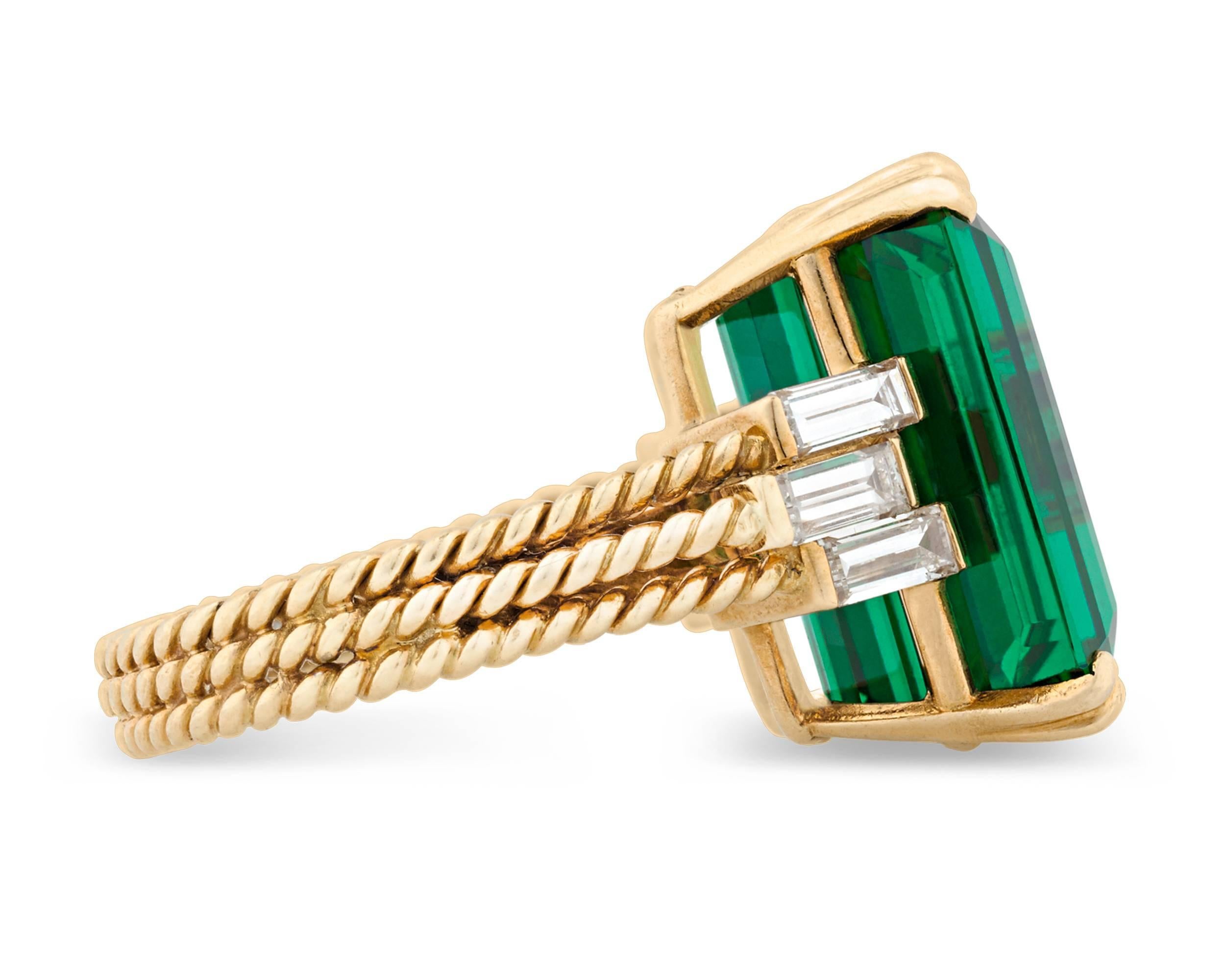 This captivating green tourmaline and diamond ring was crafted by the legendary Cartier. Absolutely brilliant with an attractive bluish-green hue, this extraordinary stone represents the tourmaline at its very best, with a rich coloration that sets