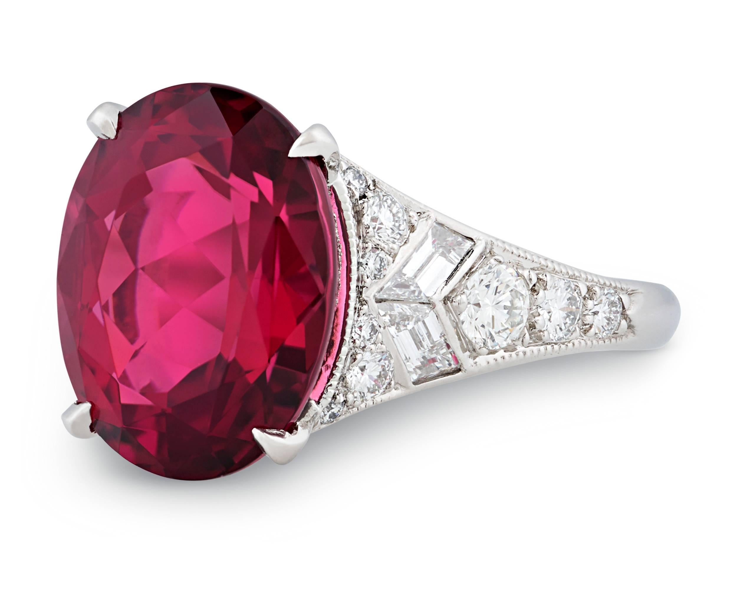 This radiant Tiffany & Co. designer ring is centered by a stunning rubellite tourmaline with a bright, richly saturated crimson hue. Weighing 6.07 carats, the gorgeous gemstone is flanked by sparkling round brilliant and baguette diamonds