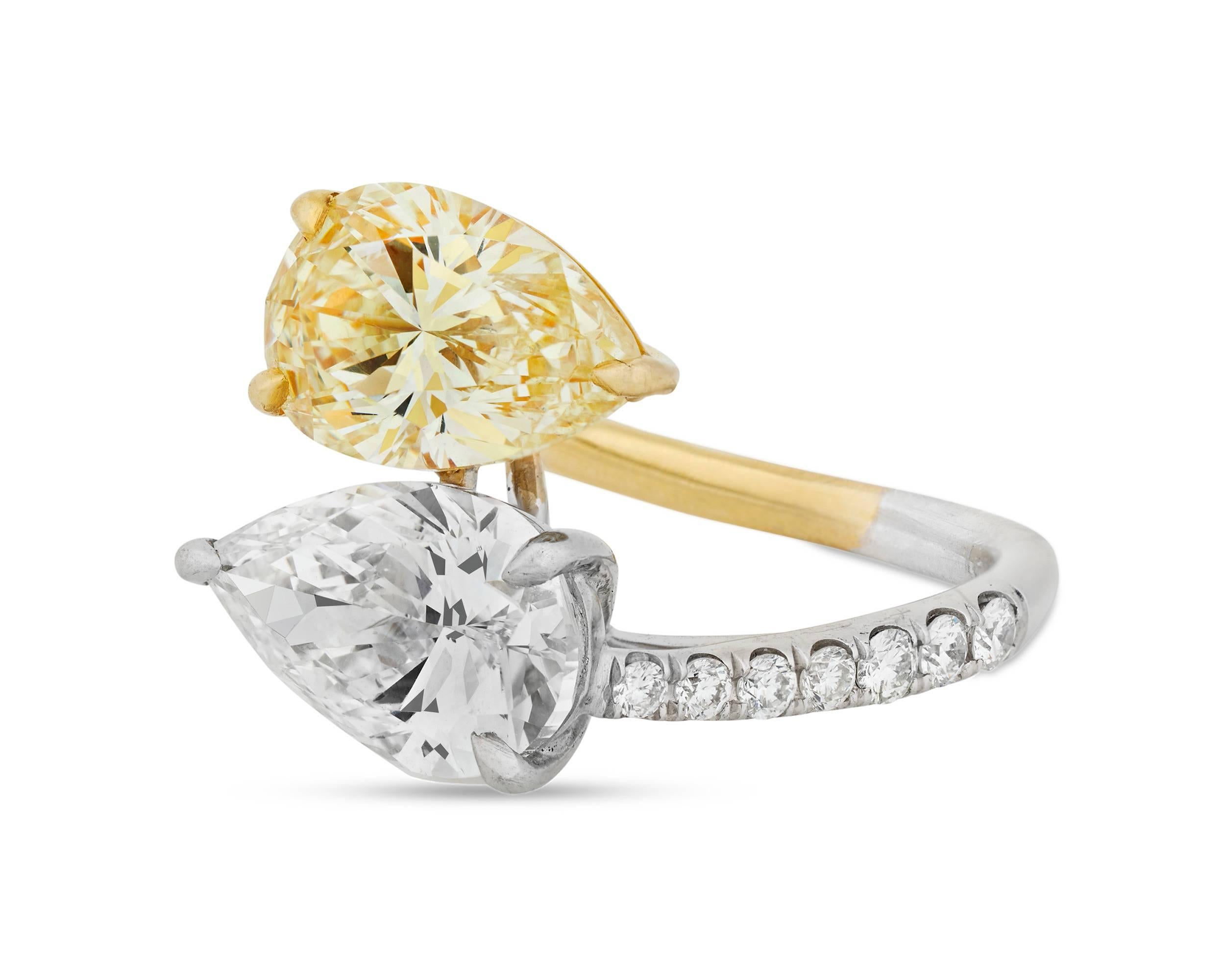 Two rare pear-shaped diamonds intersect in this exquisite bypass ring. The first, a fancy yellow diamond weighing 3.09 carats, exhibits a highly coveted canary yellow hue, making it the perfect pair to the H-color white diamond weighing 3.01