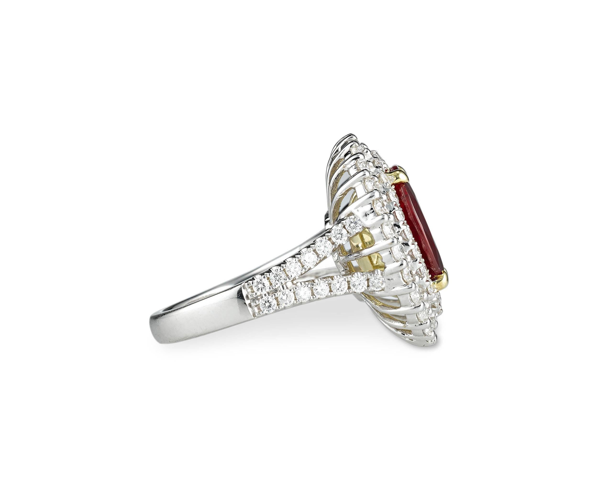 A brilliant 3.95-carat oval ruby radiates at the center of this elegant ring. The surrounding white diamonds, weighing 1.53 total carats, add to the dramatic glow of the striking gemstone. The diamonds form a bold double halo around the gem and