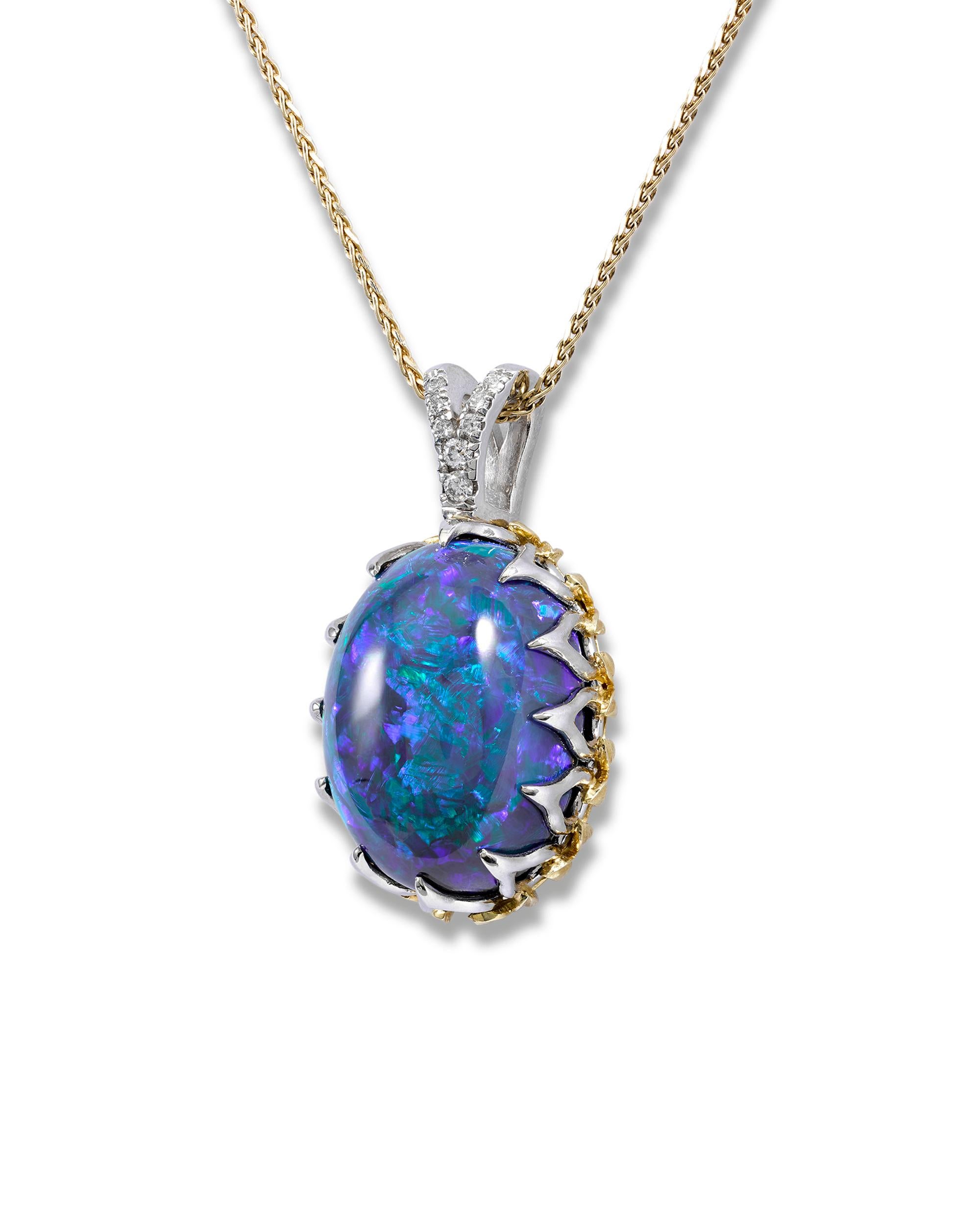 A stunning 20.56-carat black opal displays a kaleidoscope of color in this eye-catching necklace. Displaying an impressive range of iridescent blue and green hues, this extremely rare stone is complemented by approximately 0.08 carats of sparkling