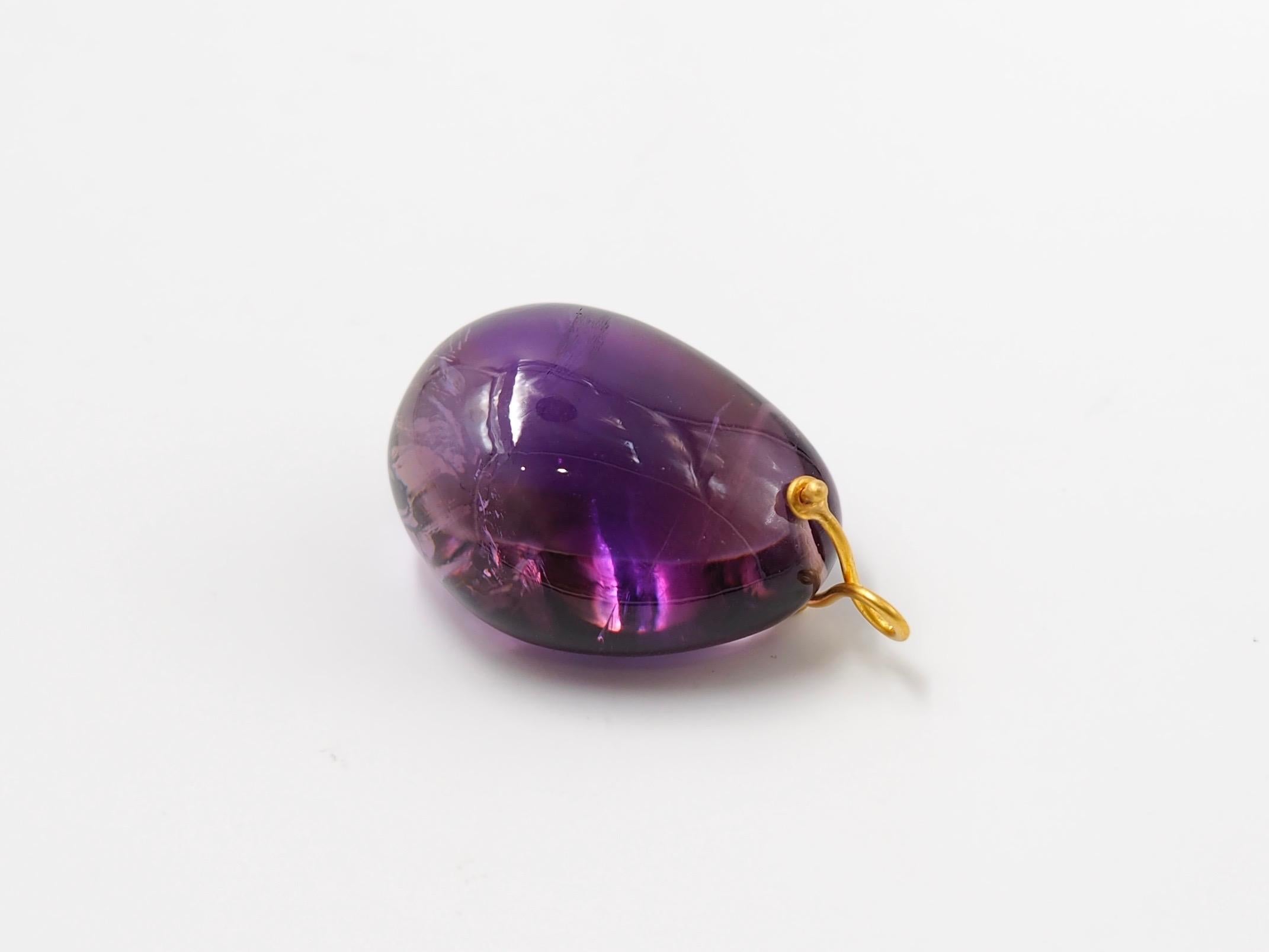 Hand-carved and handmade pendant, this stone is simply drilled to allow a 22 karat gold wire that is twisted to make a ring. 
The largest one, which is presented in the photos, has an amethyst of approx 160 carats. This amethyst has 2 tones of
