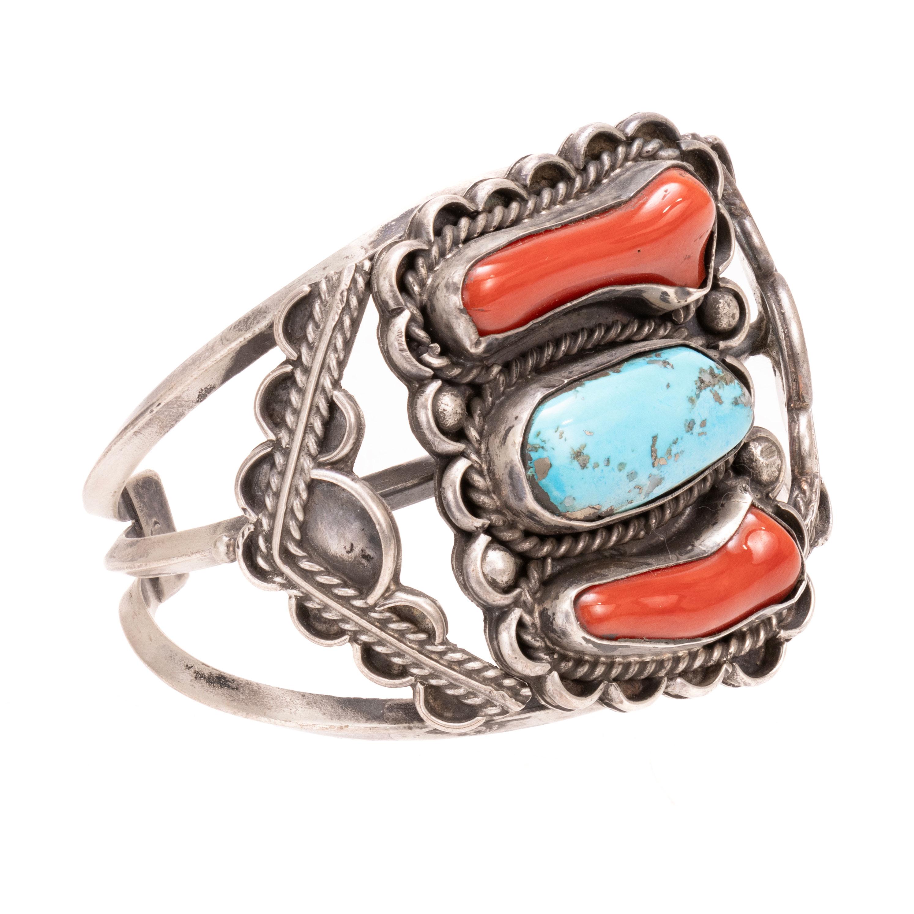 Bracciale in turchese e corallo su bracciale in argento. Con due pietre di corallo e una pietra turchese Kingman al centro, il tutto incorniciato da una corda intrecciata e da un bordo smerlato con perline in argento. Con chevron su entrambi i lati