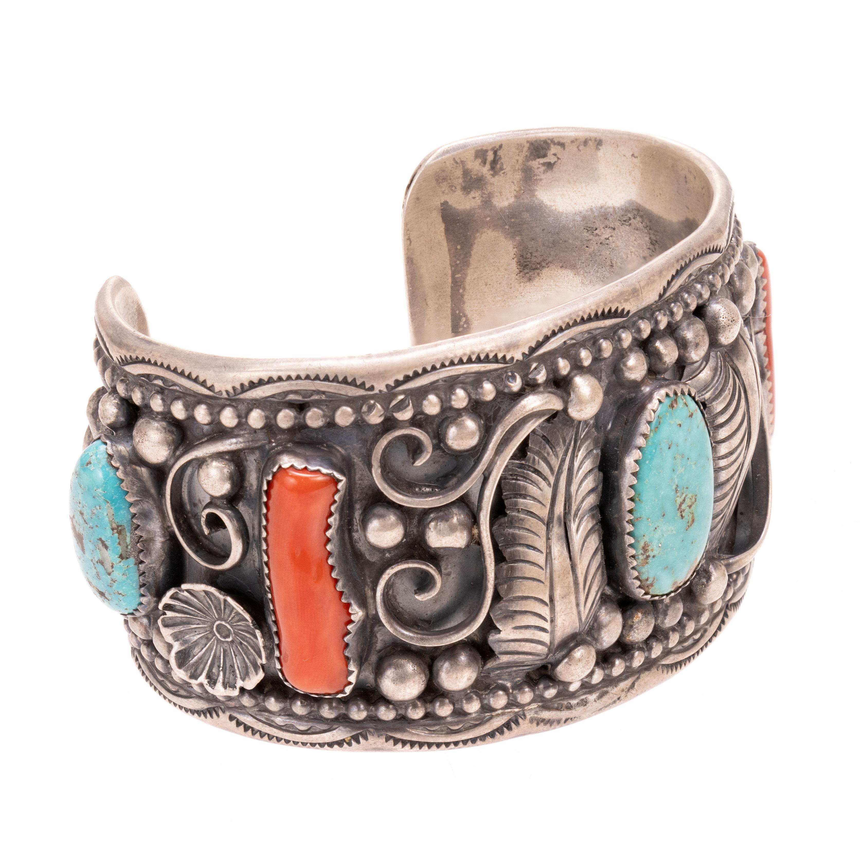 Bracciale in argento turchese e corallo. Due pietre di corallo e tre di turquosie Kingman circondano il polsino spesso, decorato con piume, perline di sterlina, disegni a spirale e timbri. Timbro 
