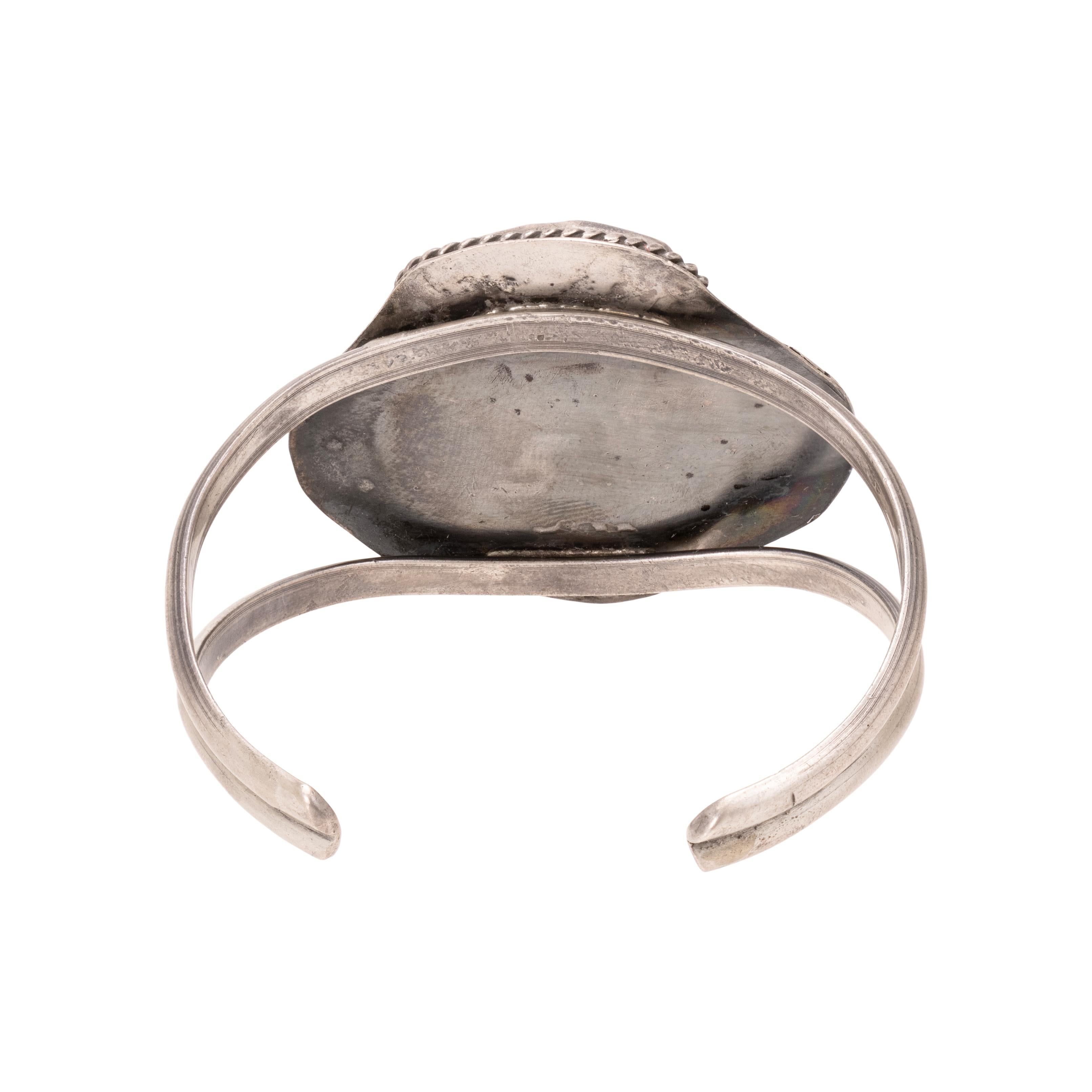 Turquoise and coral sterling silver cuff bracelet. With center shadowbox design having Cripple Creek turquoise and coral stones, framed by twisted rope and feather border. Unmarked. Old Pawn. From the Indian Store in Clovis, New Mexico. Size: 5