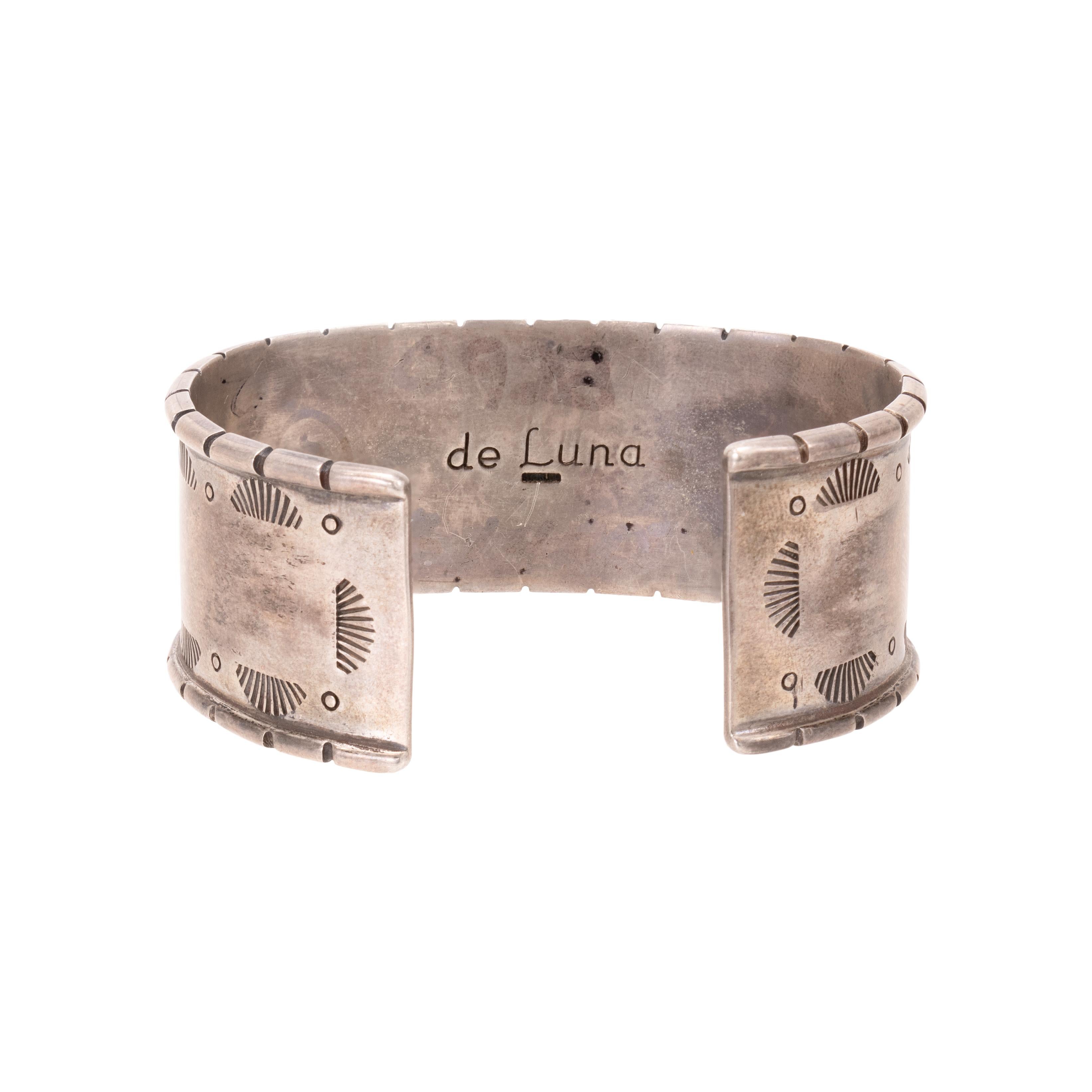Bracelet manchette en turquoise Navajo et argent sterling. Cinq turquoises Red Mountain sont serties en relief sur une manchette en argent massif, décorée de perles en argent, de motifs estampés sur les côtés et de marques de hachures sur les bords.