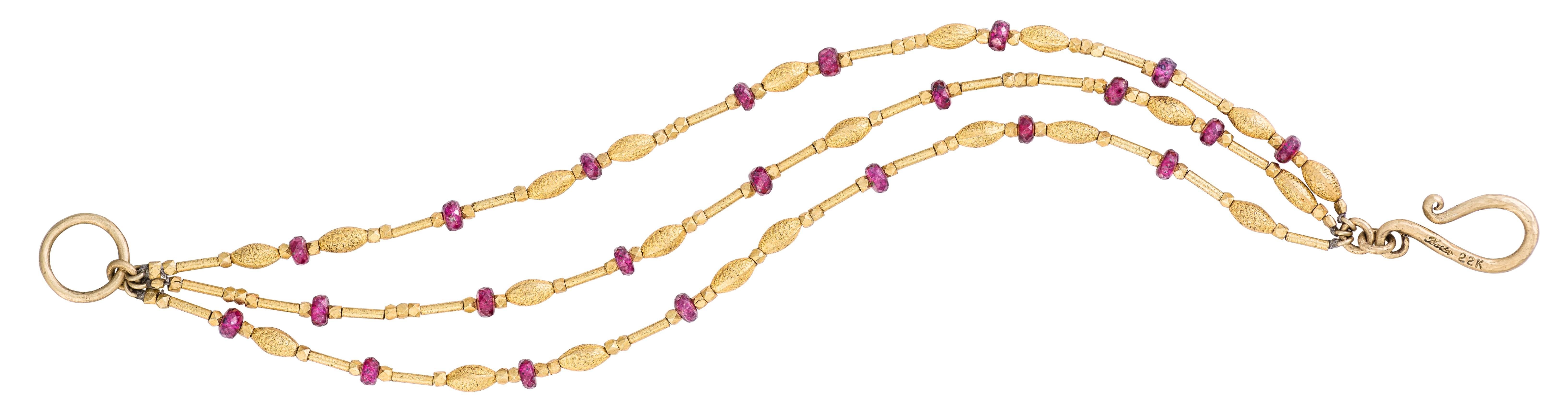A total of twenty-two beautiful rubies adorn this gold bracelet. A sparkling, "brushed" effect on some of the gold beads adds a touch of sophistication to this already elegant design. Beautiful on any skin tone, the deep gold hues are