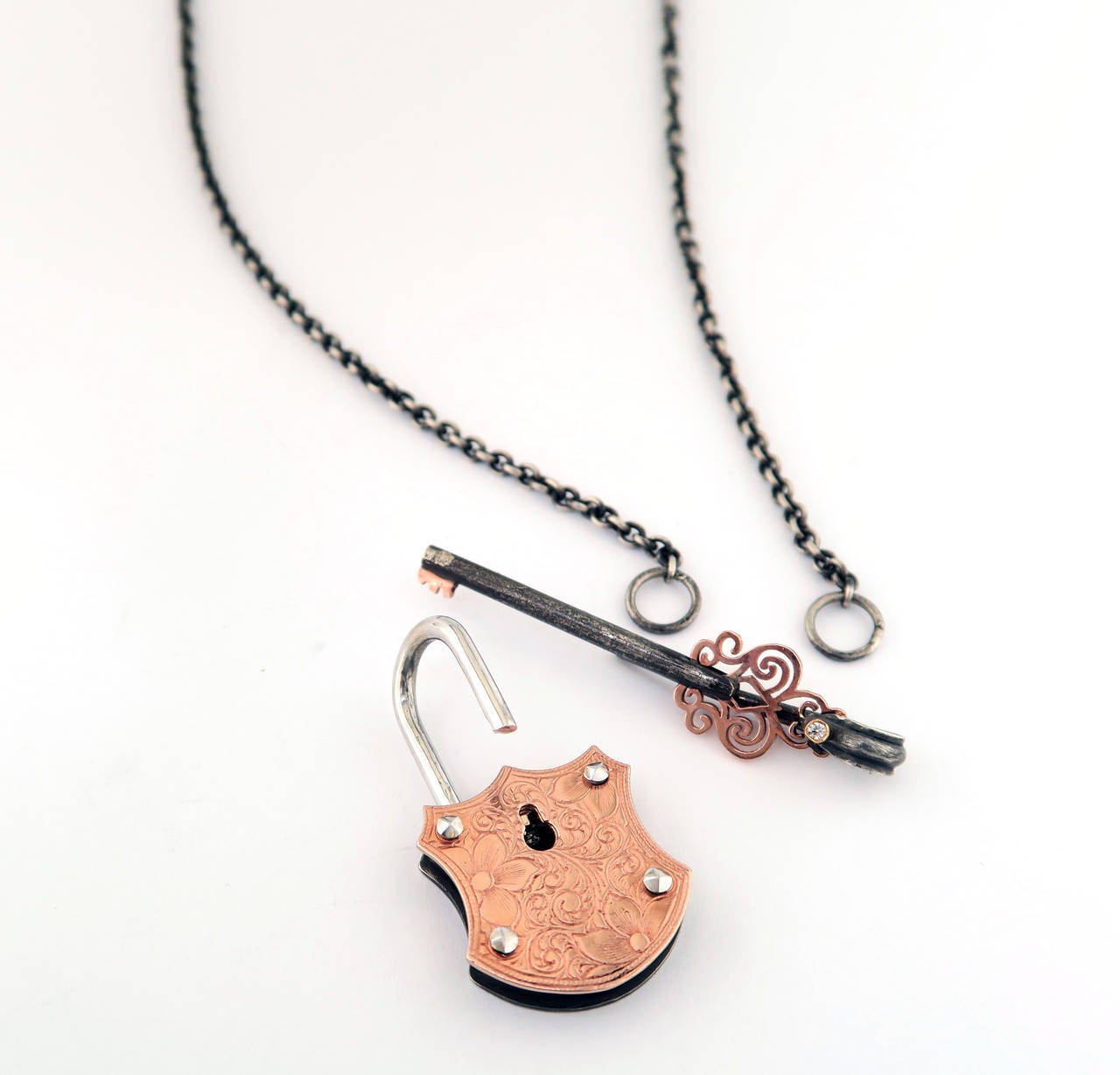 18 Karat Rose Gold, 18 Karat White Gold, and Organic Silver Pendant on a 22" Organic Silver Chain. 

The delicate tone of rose gold complemented by the rustic, patina finish creates a piece that evokes classic elegance in a very modern way.