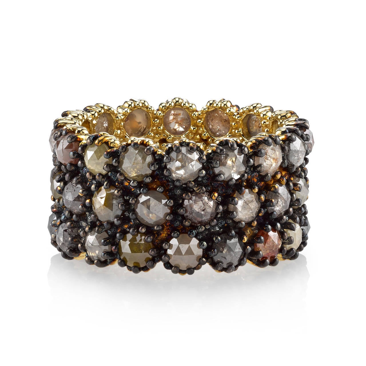 This 18 Karat Yellow Gold band is perfect for a woman on the cutting edge of style that isn't afraid to make a bold statemenet. The Black Rhodium finish perfectly comliments the muted, Earth tones of the Rustic Diamonds that elegantly wrap around