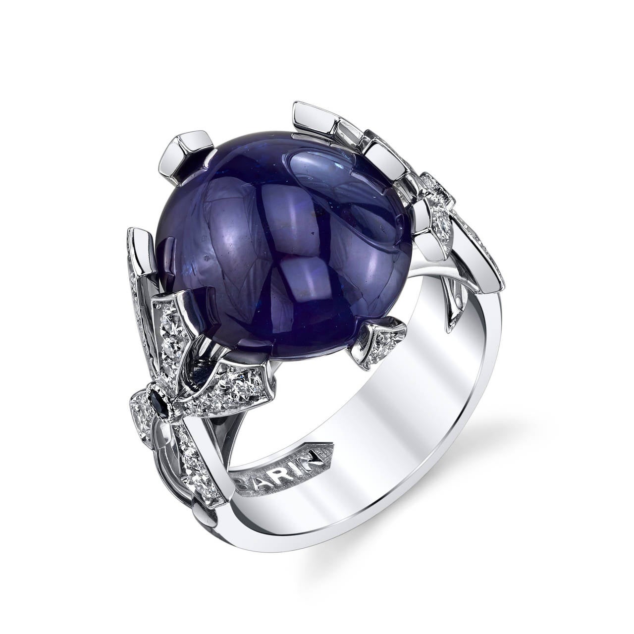 A unique ring with an intricate design,  this is truly a work of art that will get you noticed. The center stone, a GIA Certified Cabochon Cut Sapphire, is suspended by whimsical White Gold prongs that are studded with Diamonds and Sapphires.